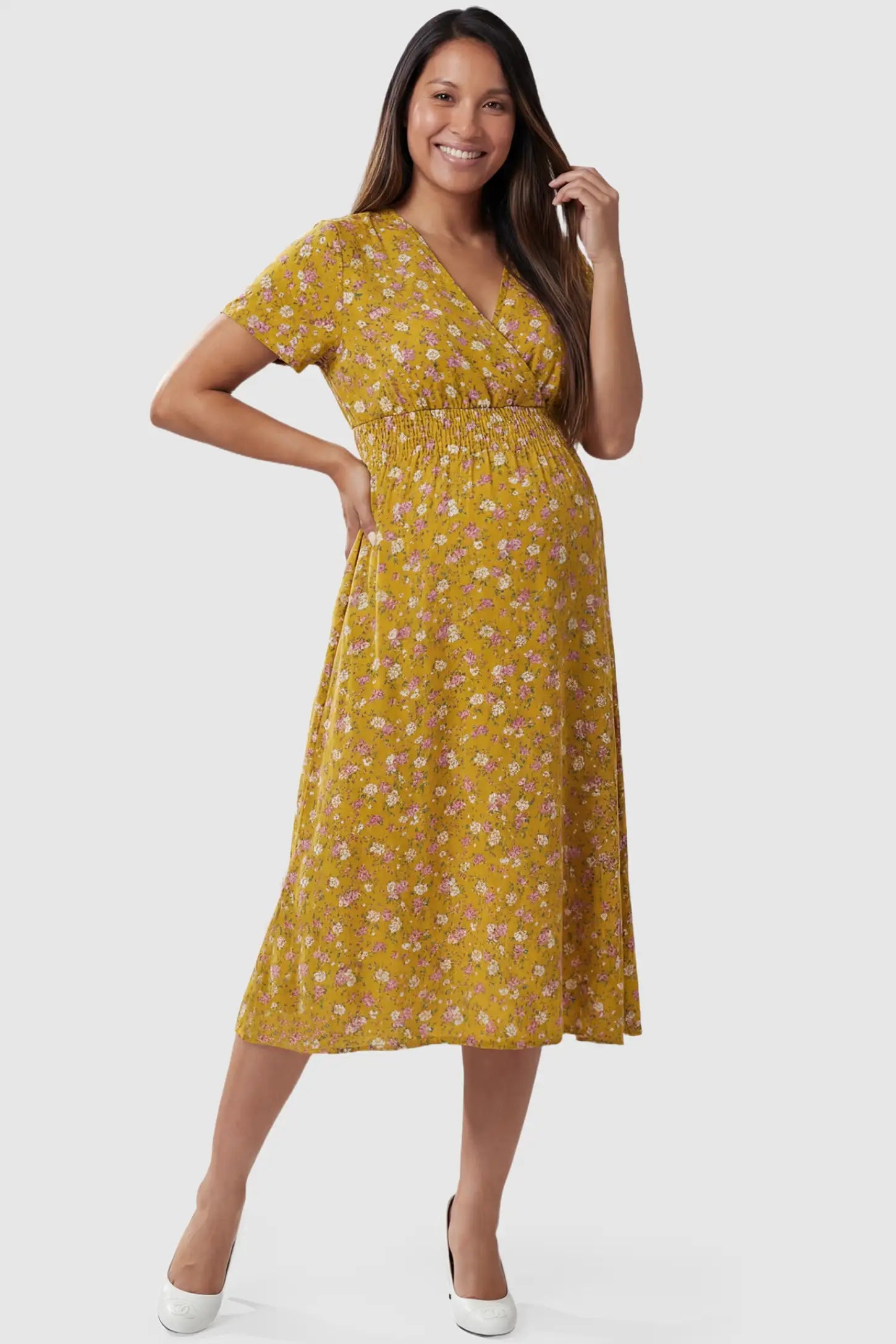 Smocked Waist Crossover Maternity Midi Dress in yellow floral print featuring V-neck wrap bodice and A-line midi skirt on pregnant model.