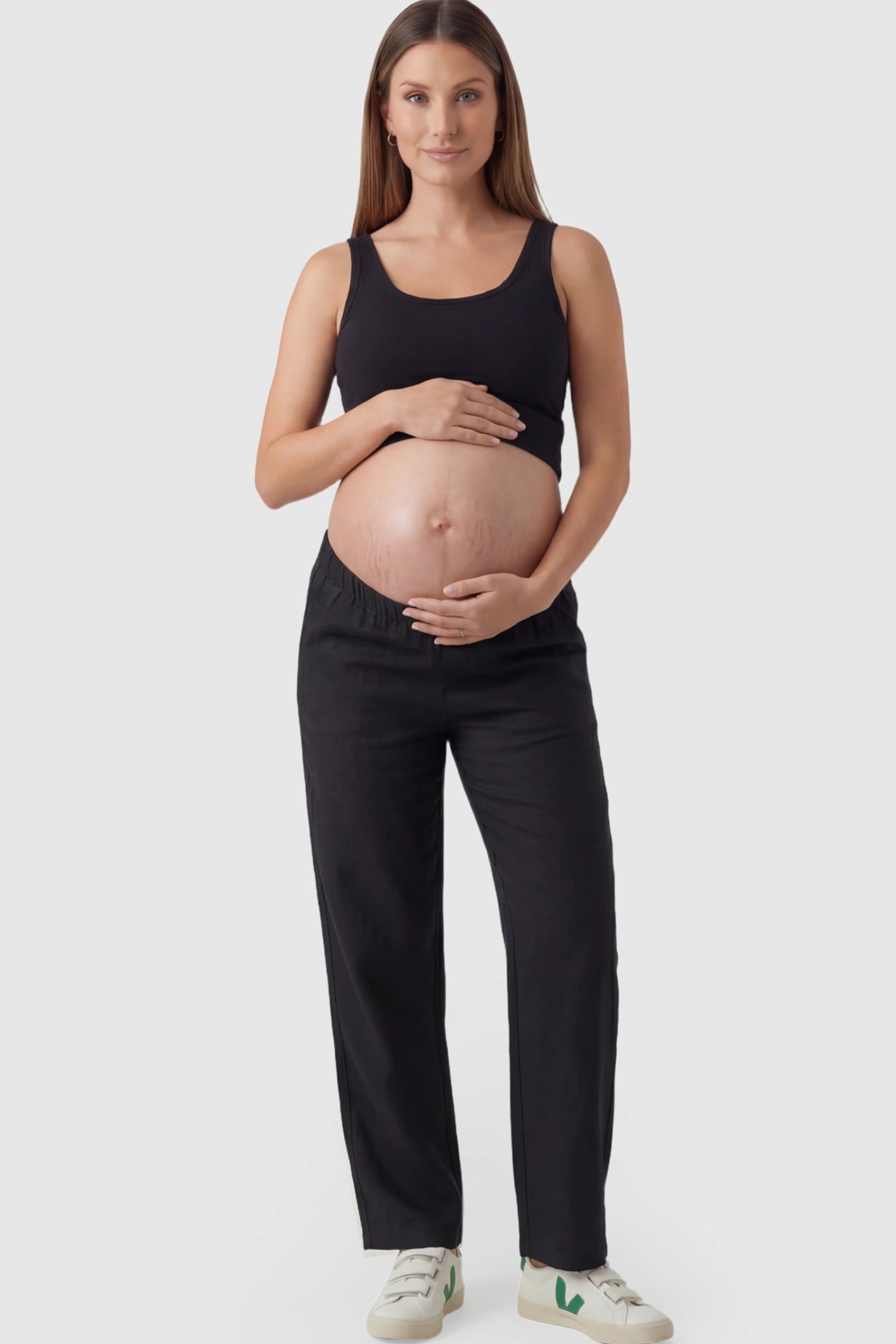 Adjustable Elastic Waist Wide-Leg Maternity Pants in Black featuring a customizable button-hole waistband on a pregnant model facing front.