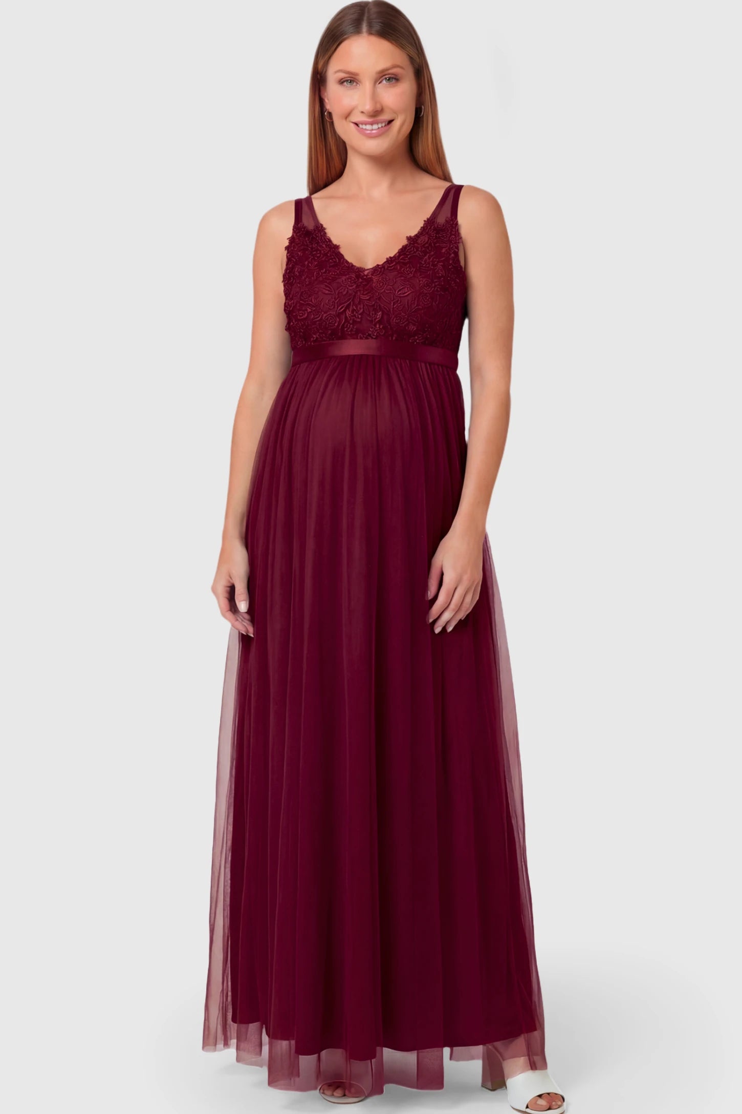 Sleeveless A-line Maternity Gown in wine red featuring lace-trimmed V-neck and empire waist on pregnant model.