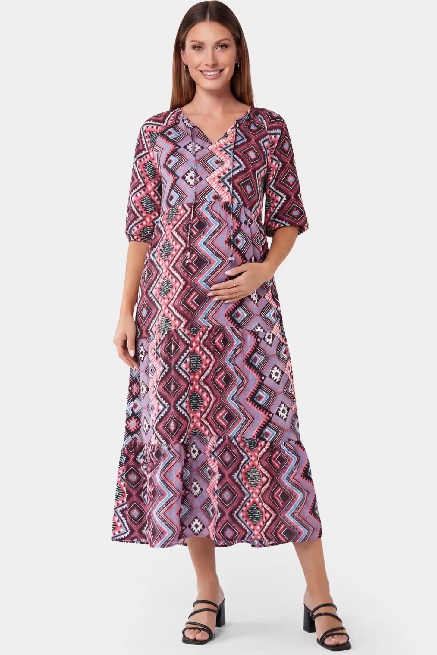 Bohemian print V-neck A-line maxi maternity dress in red featuring artistic boho print in front view on a pregnant model