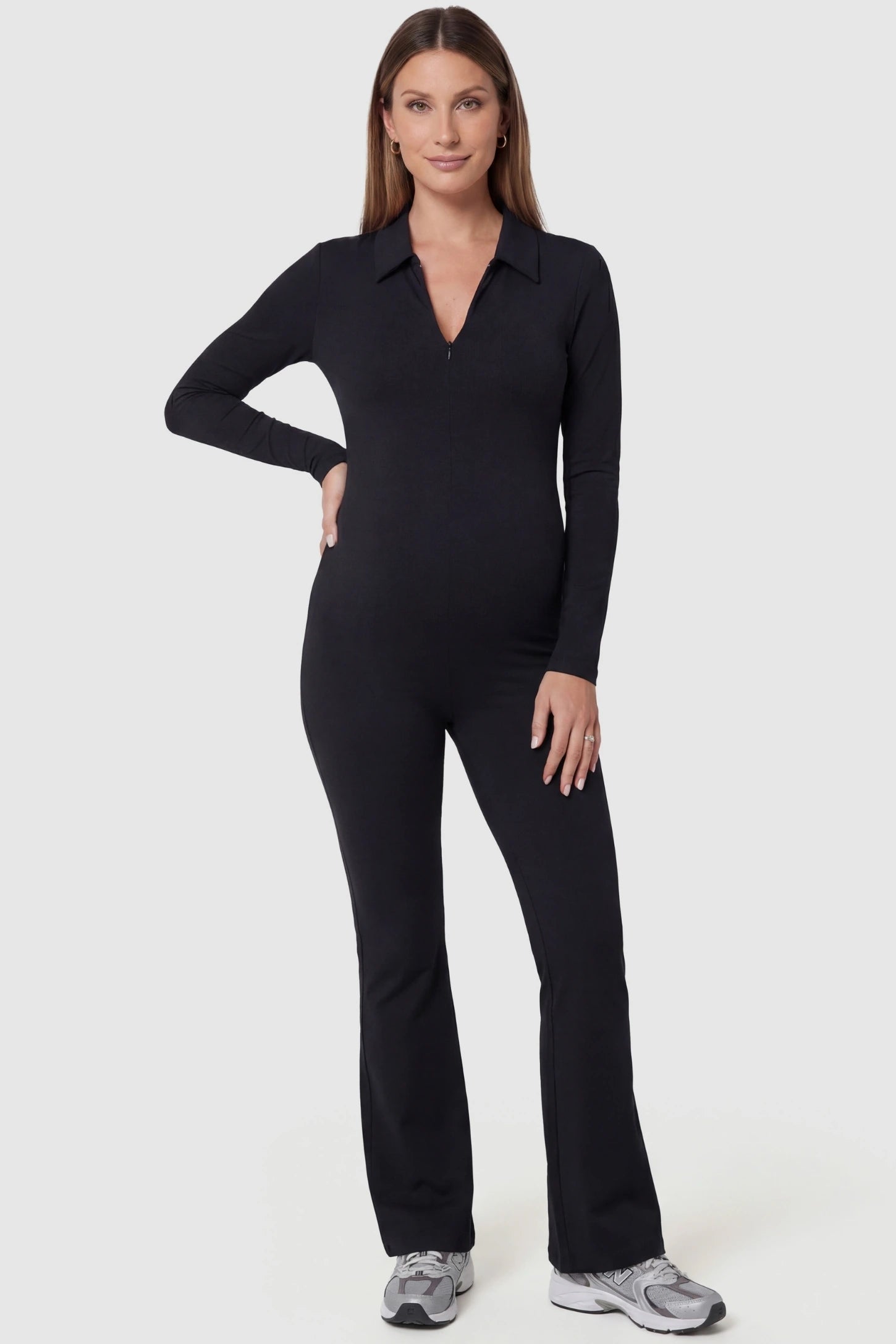 Collared Zip-Front Flared Maternity Jumpsuit in Black featuring a figure shaping silhouette on a pregnant model, front view.
