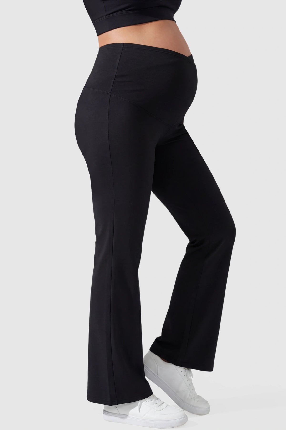 Cross Over High-Waisted Wide-Leg Maternity Pants in Black featuring a supportive V-waistband on a pregnant mode side view.