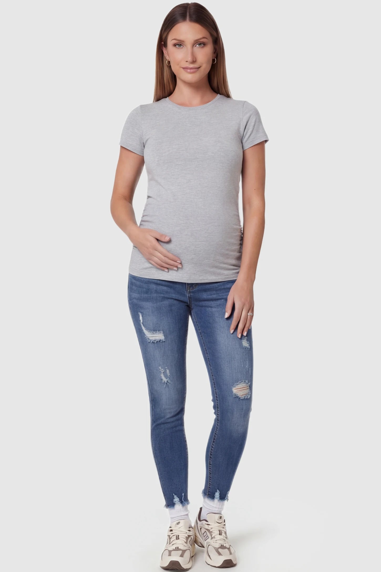 High-Rise Distressed Skinny Maternity Jeans in navy blue featuring over-the-belly support panel and frayed hem on a front view pregnant model.