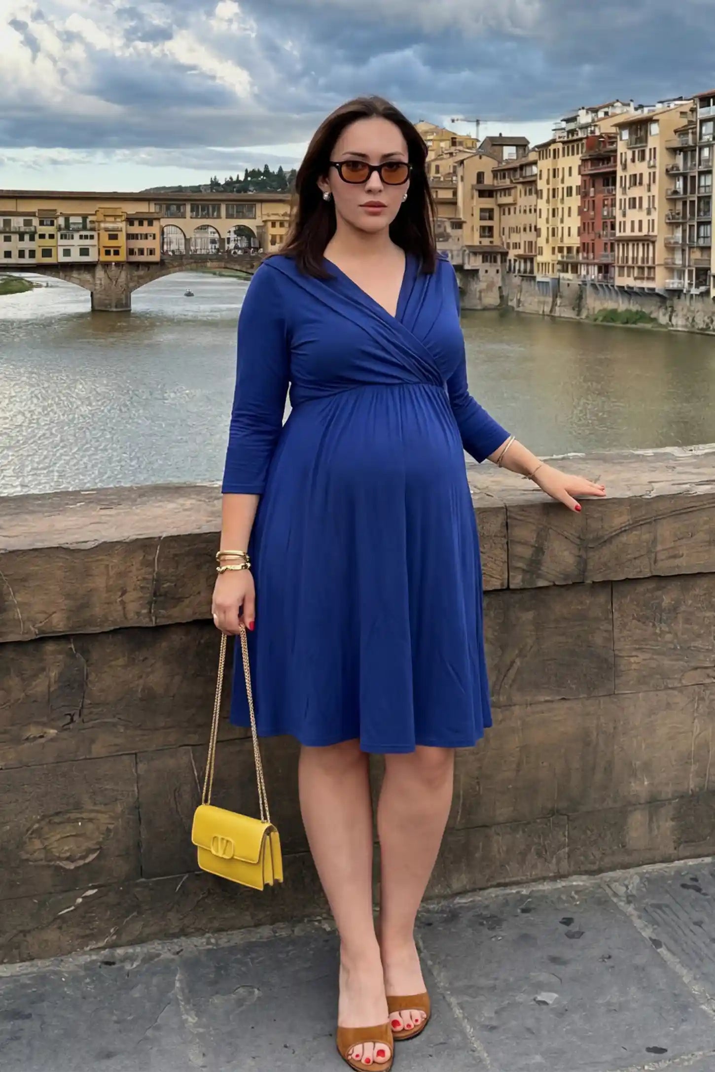 Crossover A-line maternity & nursing midi dress in navy blue with wrap-style V-neck bodice, front view on pregnant model
