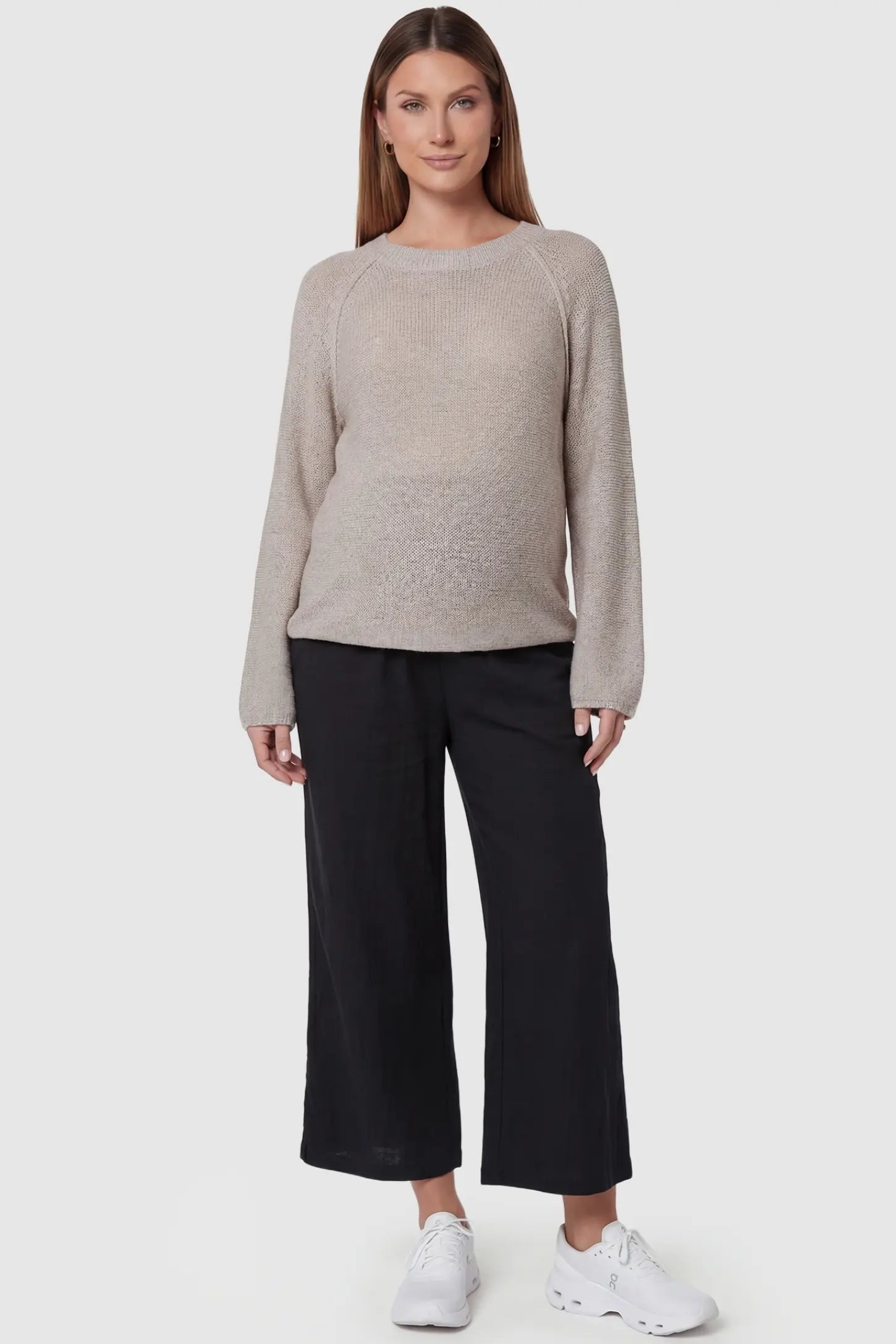 Elastic High Waisted Cropped Maternity Pants in Black featuring a supportive belly band on a pregnant model, front view.