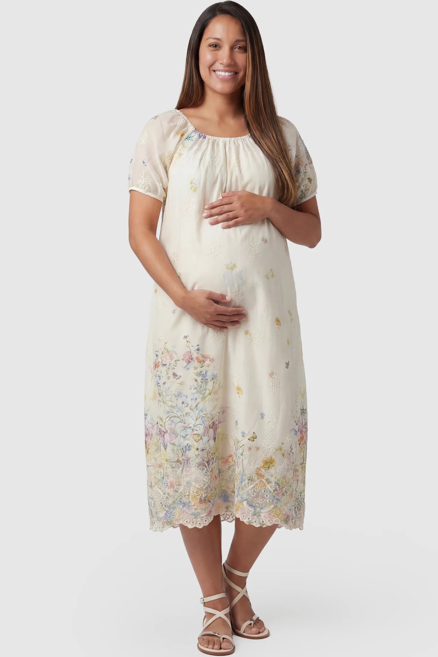 Embroidered floral convertible neckline maternity midi dress in beige with embroidered floral detail and puff sleeves, front view on pregnant model