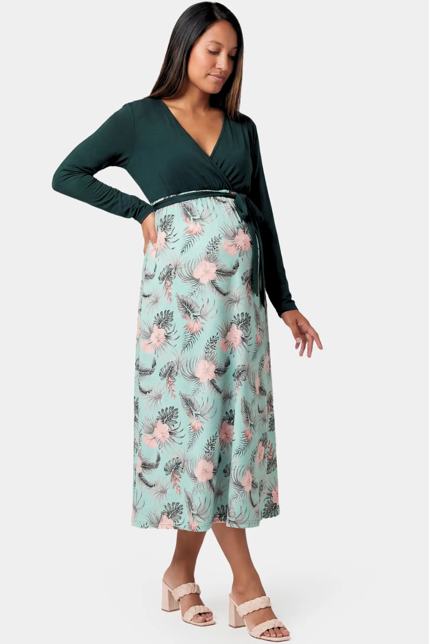 Empire Waist Faux Wrap Maternity & Nursing Midi Dress in green floral featuring long sleeves and V-neck wrap detail on a pregnant model.