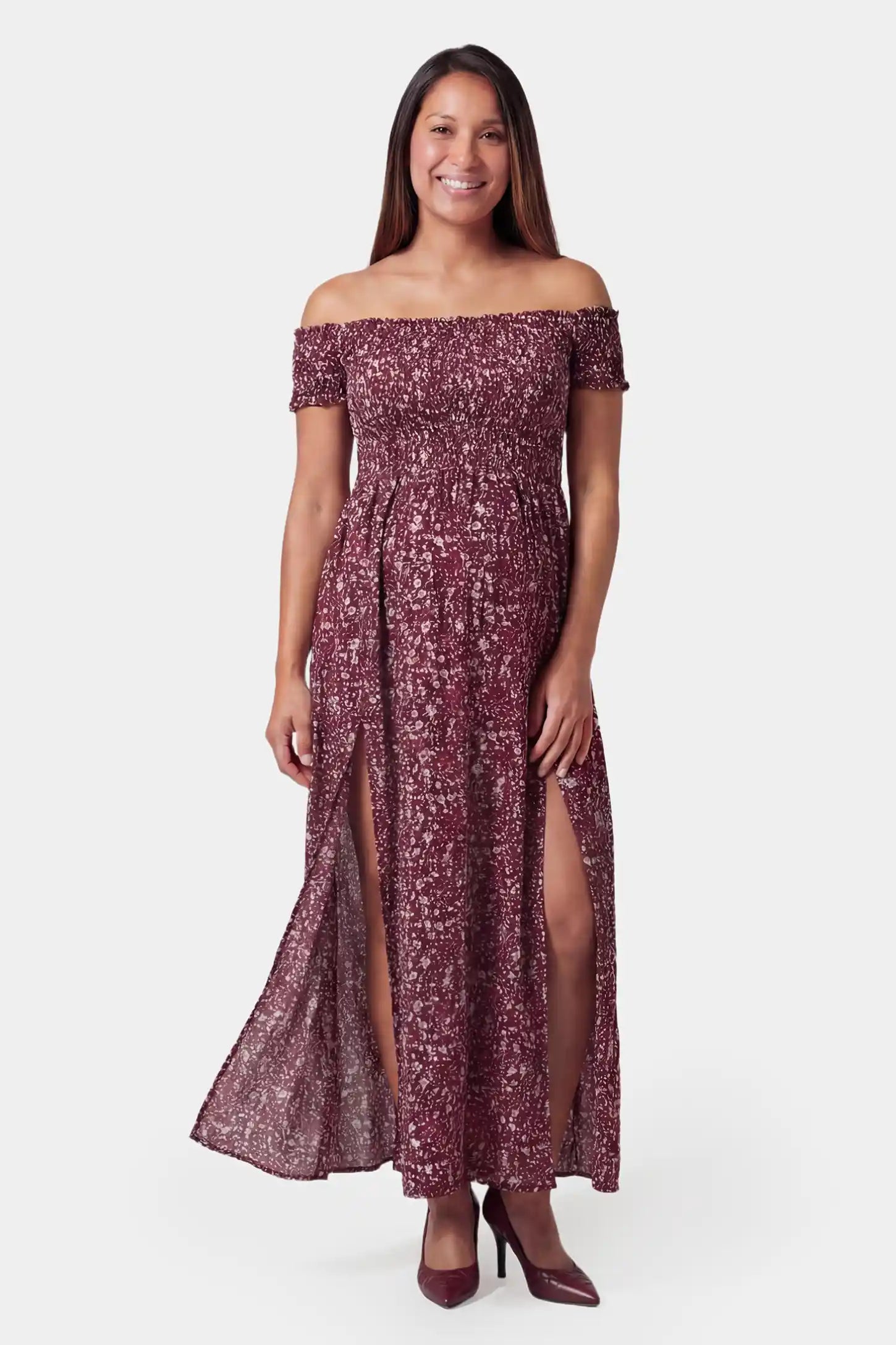 Floral off-shoulder smocked bodice maxi maternity dress in burgundy featuring smocked neckline in front view on a pregnant model