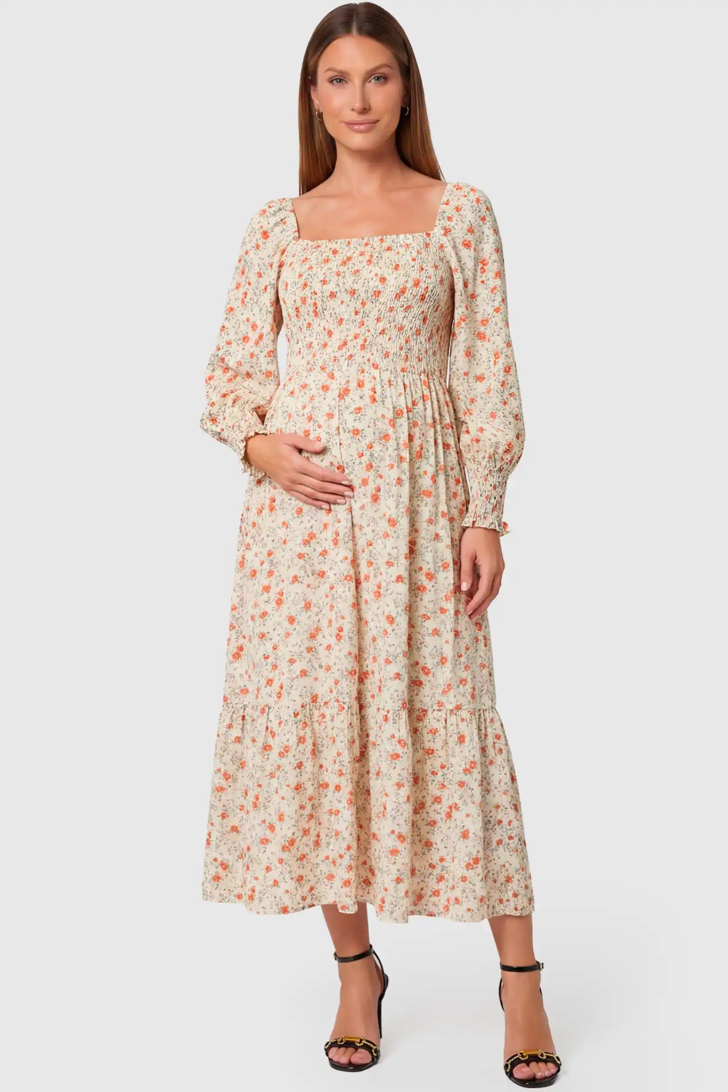 Floral Smocked Tiered Maternity Midi Dress in white floral print featuring square neckline, puff sleeves, and tiered midi skirt on pregnant model, front view