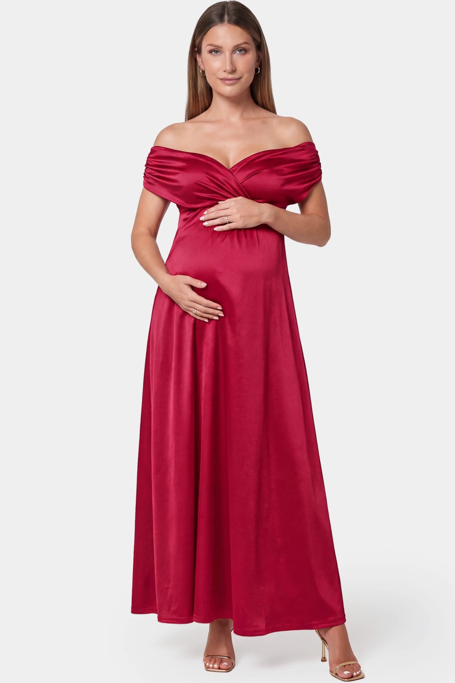Off-shoulder fitted waist flowing maxi maternity dress in red featuring off-shoulder neckline in front view on a pregnant model