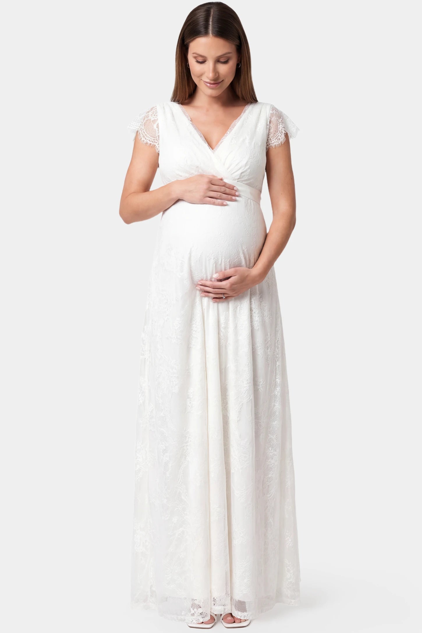 Lace flutter sleeve V-neck maxi maternity dress in white featuring V-neckline and lace splicing in front view on a pregnant model