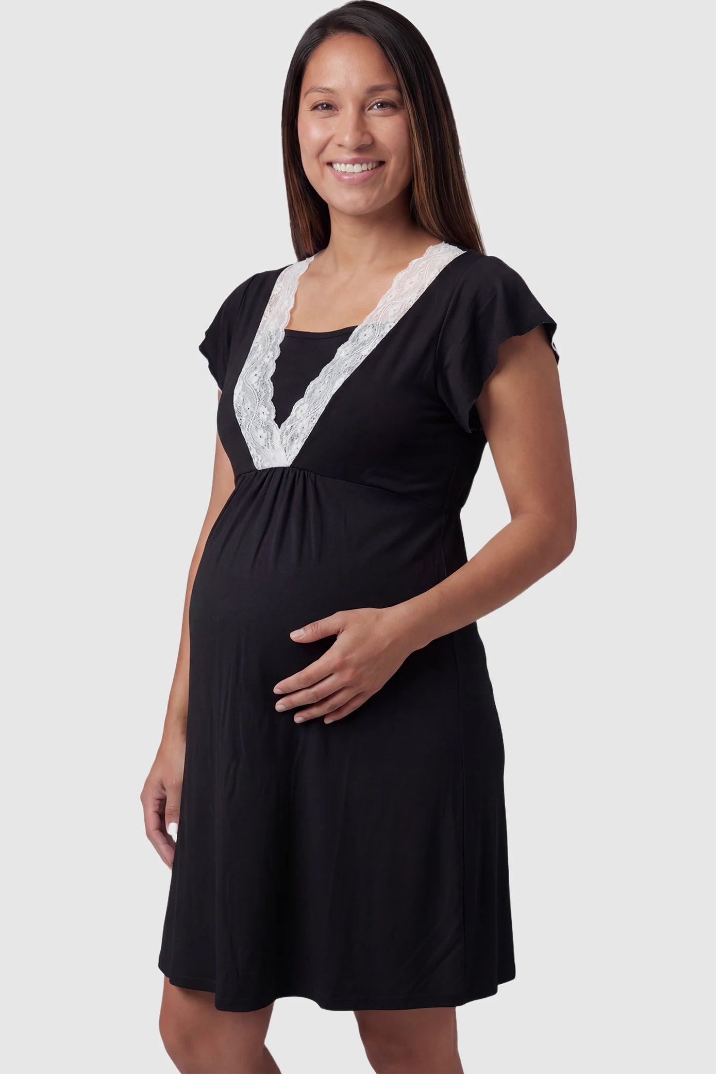 Lace trim V-neck maternity nursing sleep dress in black with empire waist and relaxed A-line fit on pregnant model front view.