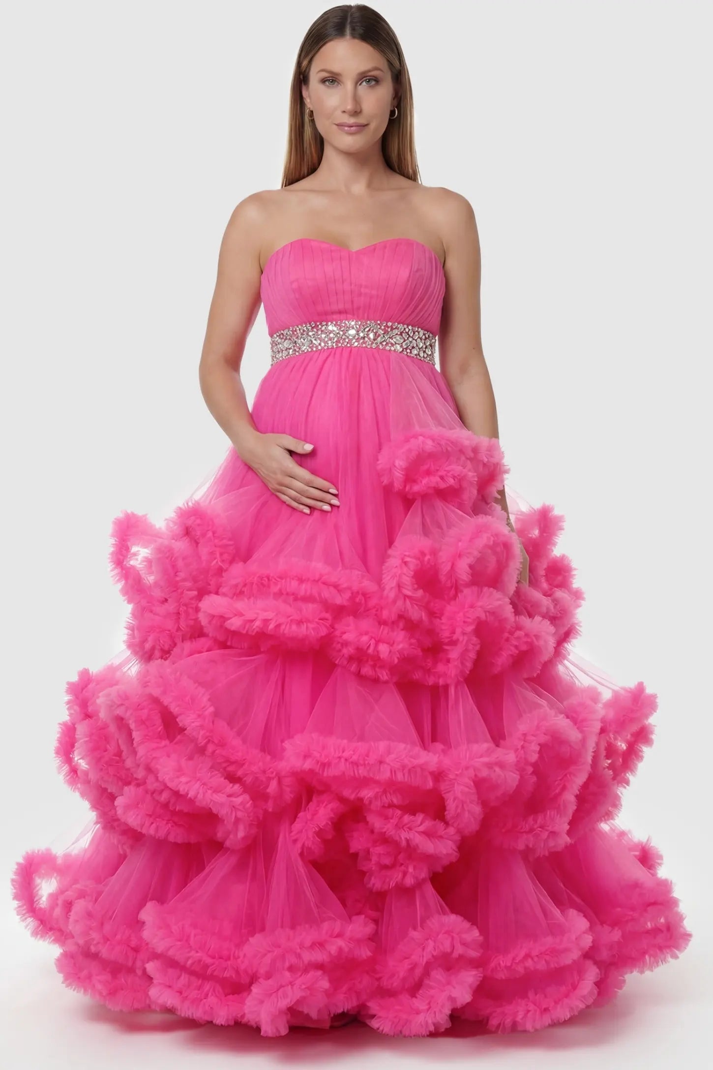 Multi-layered pleated tulle strapless bodice maxi maternity gown in rose red featuring structured strapless bodice in front view on a pregnant model
