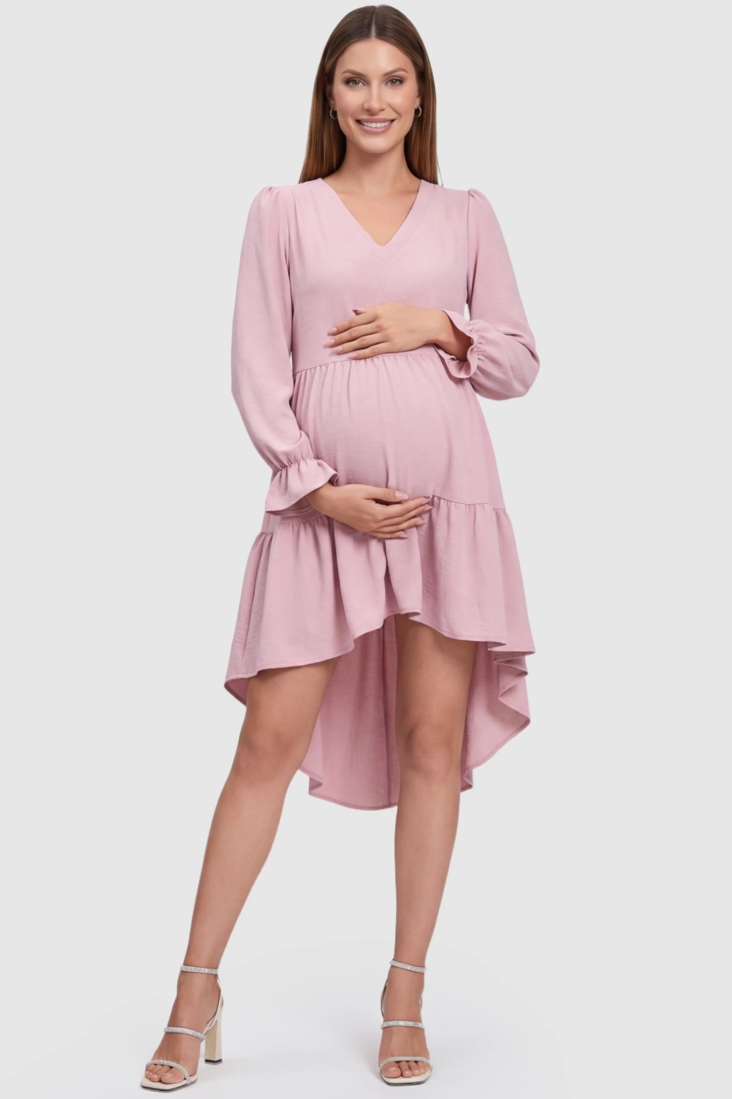 Fishtail Hem Tie-Back Maternity Mini Dress in Pink featuring a V-neckline and ruffles on a pregnant model.