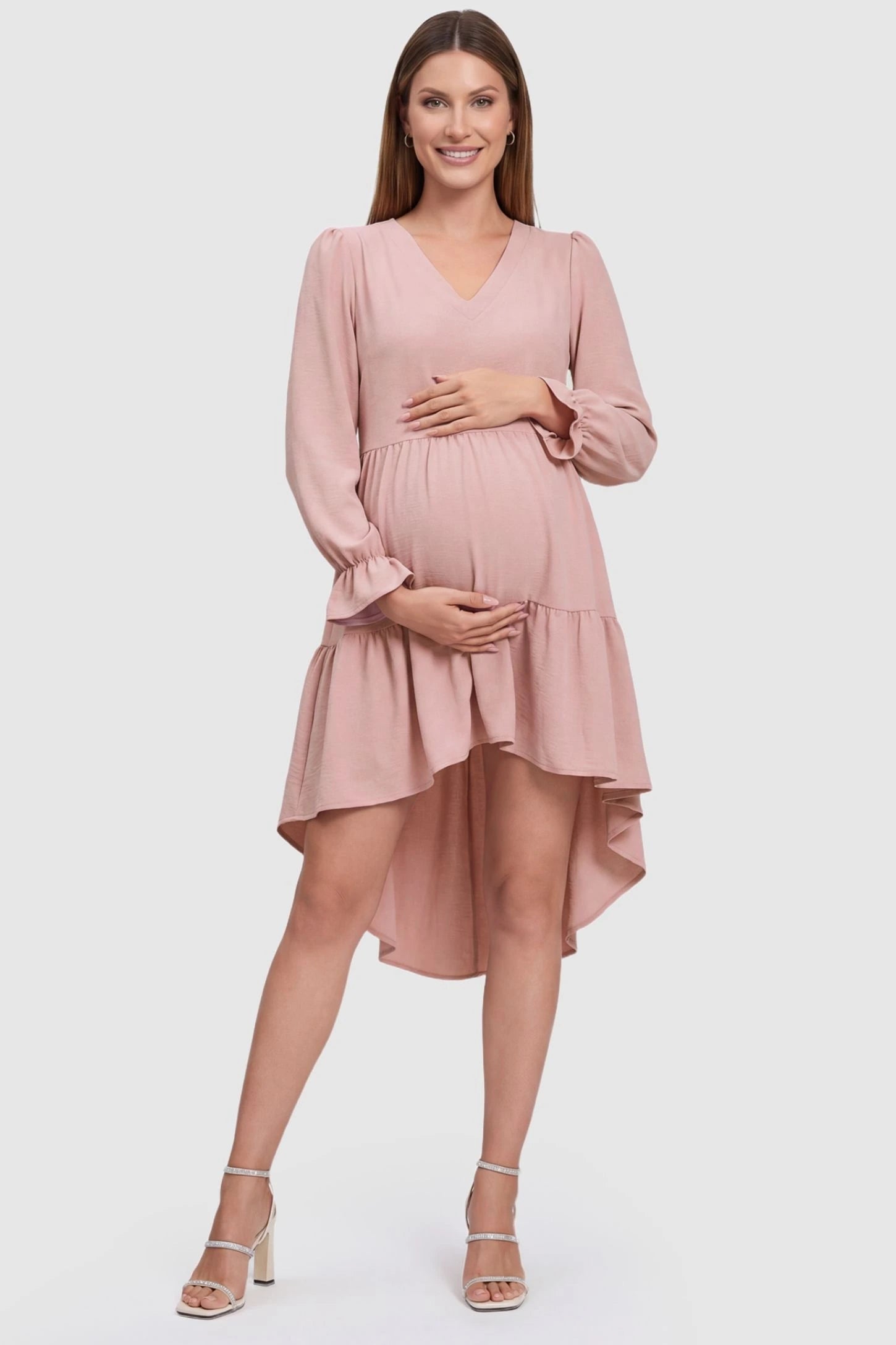 Fishtail Hem Tie-Back Maternity Mini Dress in Pink featuring a V-neckline and ruffles on a pregnant model, front view.