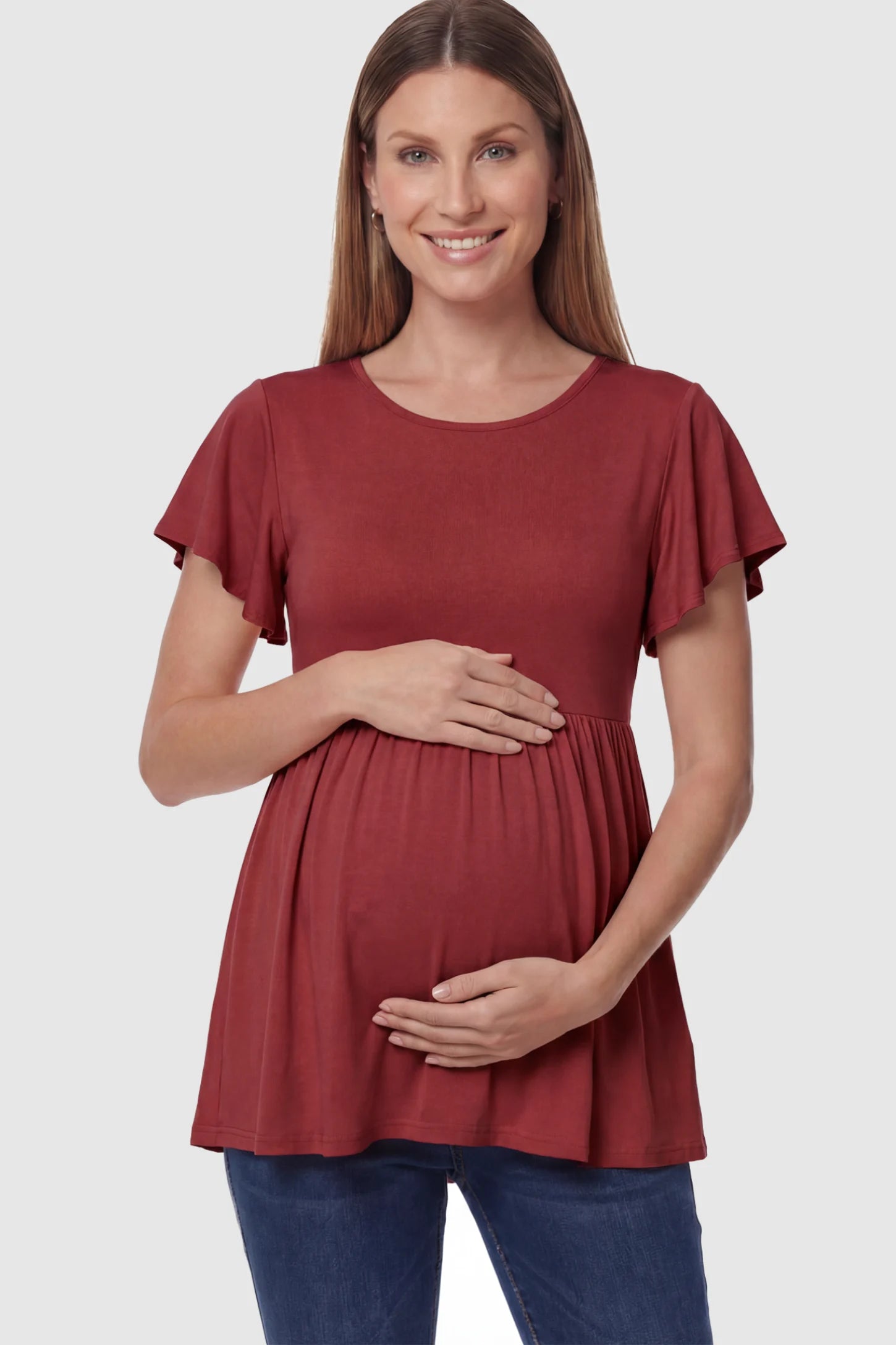 Solid Ruffled-Sleeve Flowy Maternity Top in Red featuring a pleated empire waist on a pregnant model in front view.