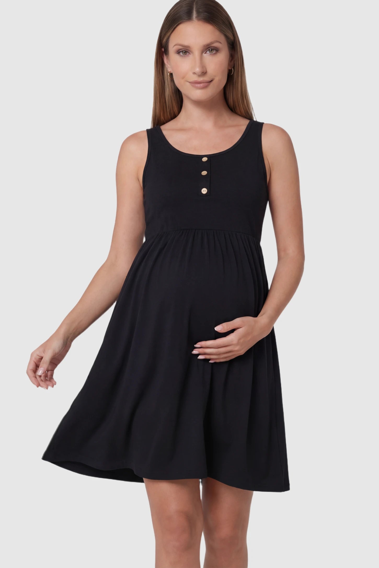 Button Accent Sleeveless Maternity Short Dress in Black featuring an empire waist on a pregnant model.