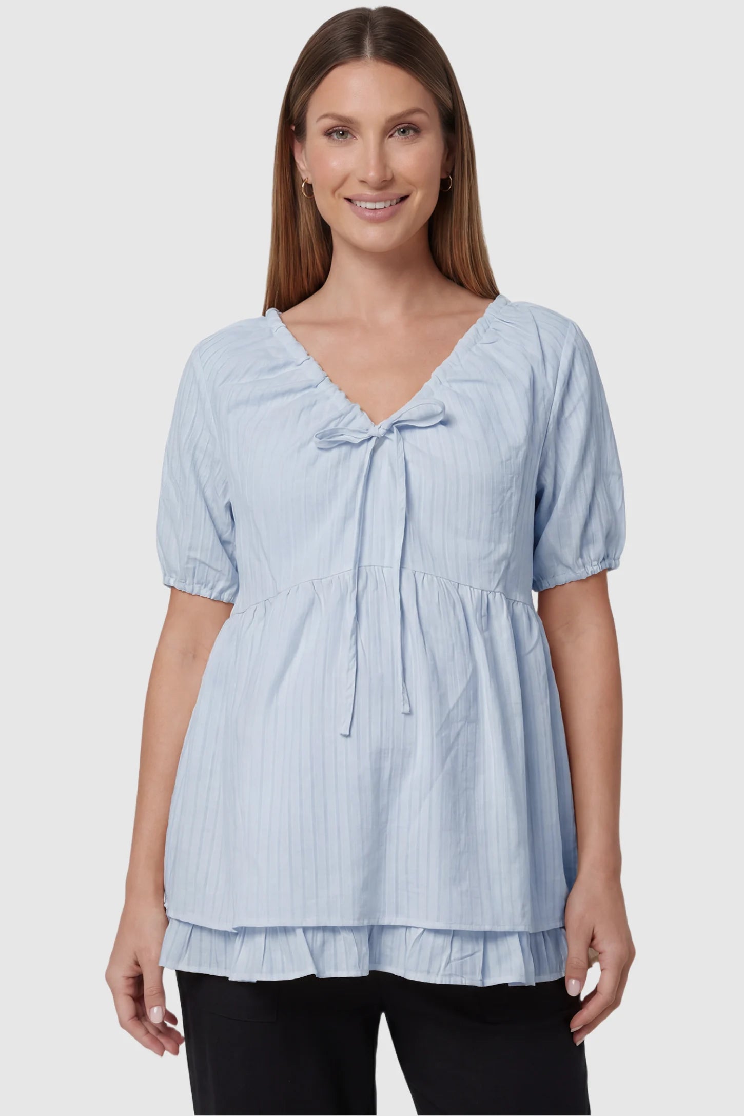 Drawstring V-neck peplum maternity top in blue with drawstring V-neck detail and puff sleeves, front view on pregnant model