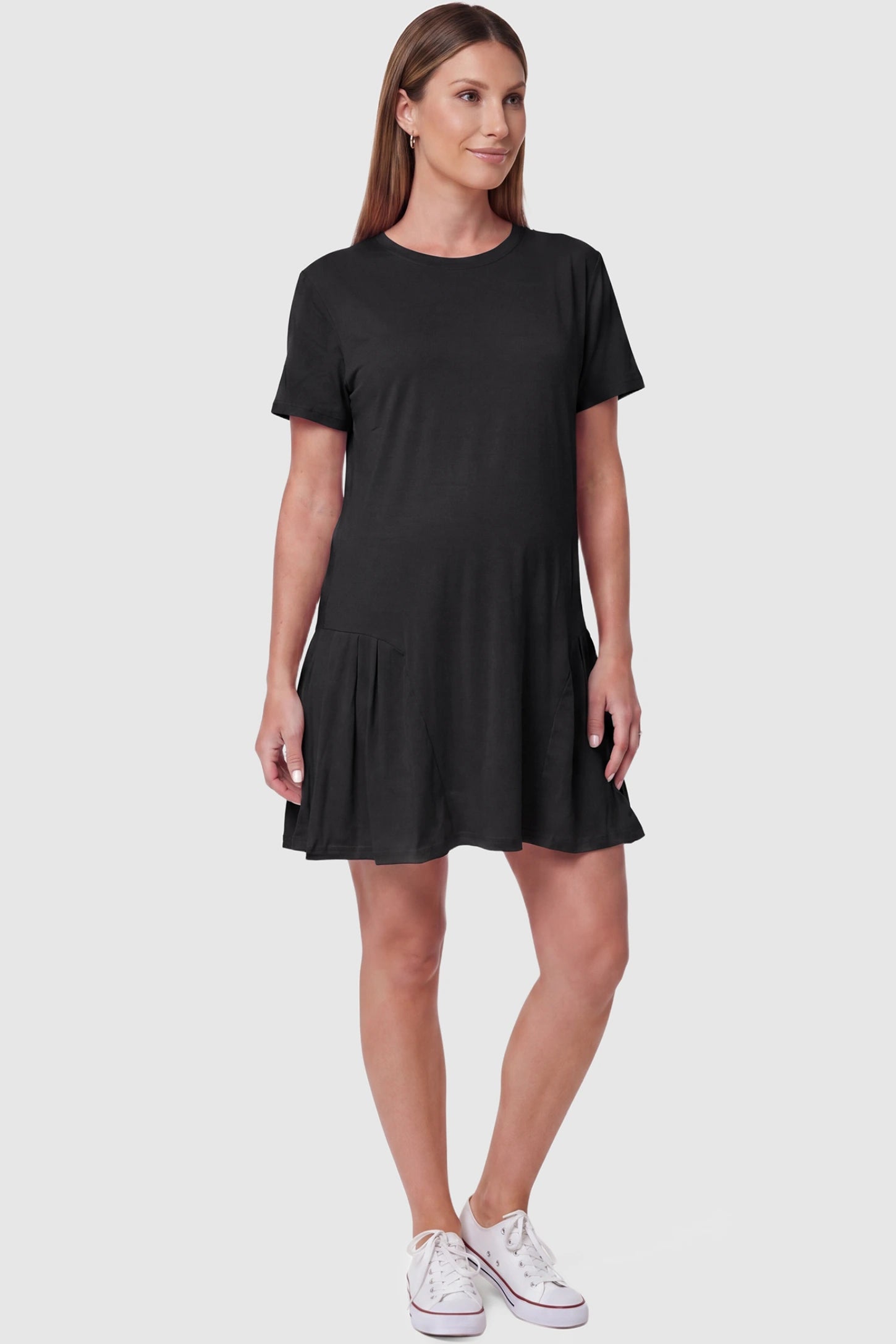 Pleated hem A-line maternity short dress in black with classic round neckline, front view on pregnant model
