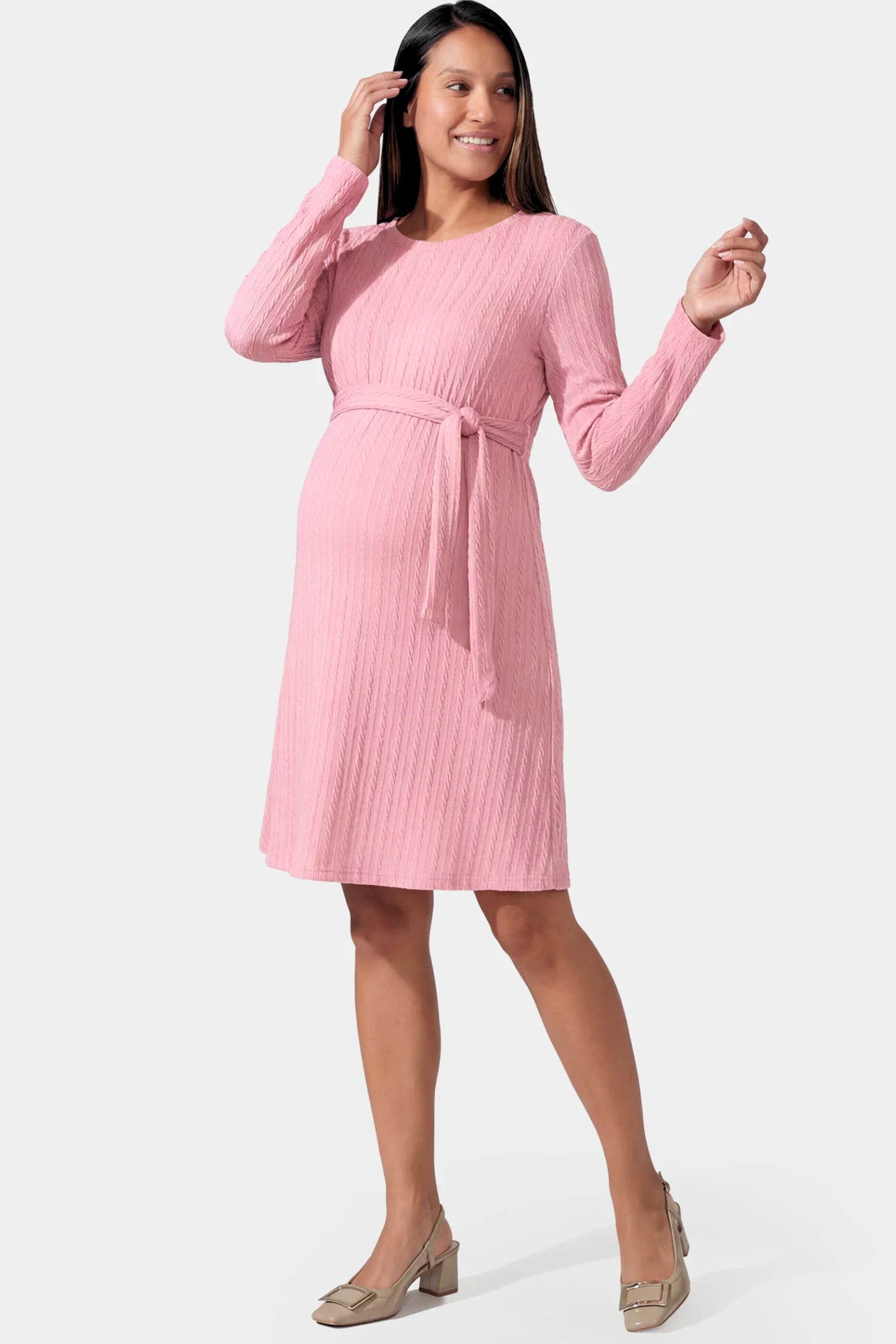Ribbed Knit Long Sleeve Maternity Short Dress in pink featuring a ribbed texture and adjustable tie waist on a pregnant model.
