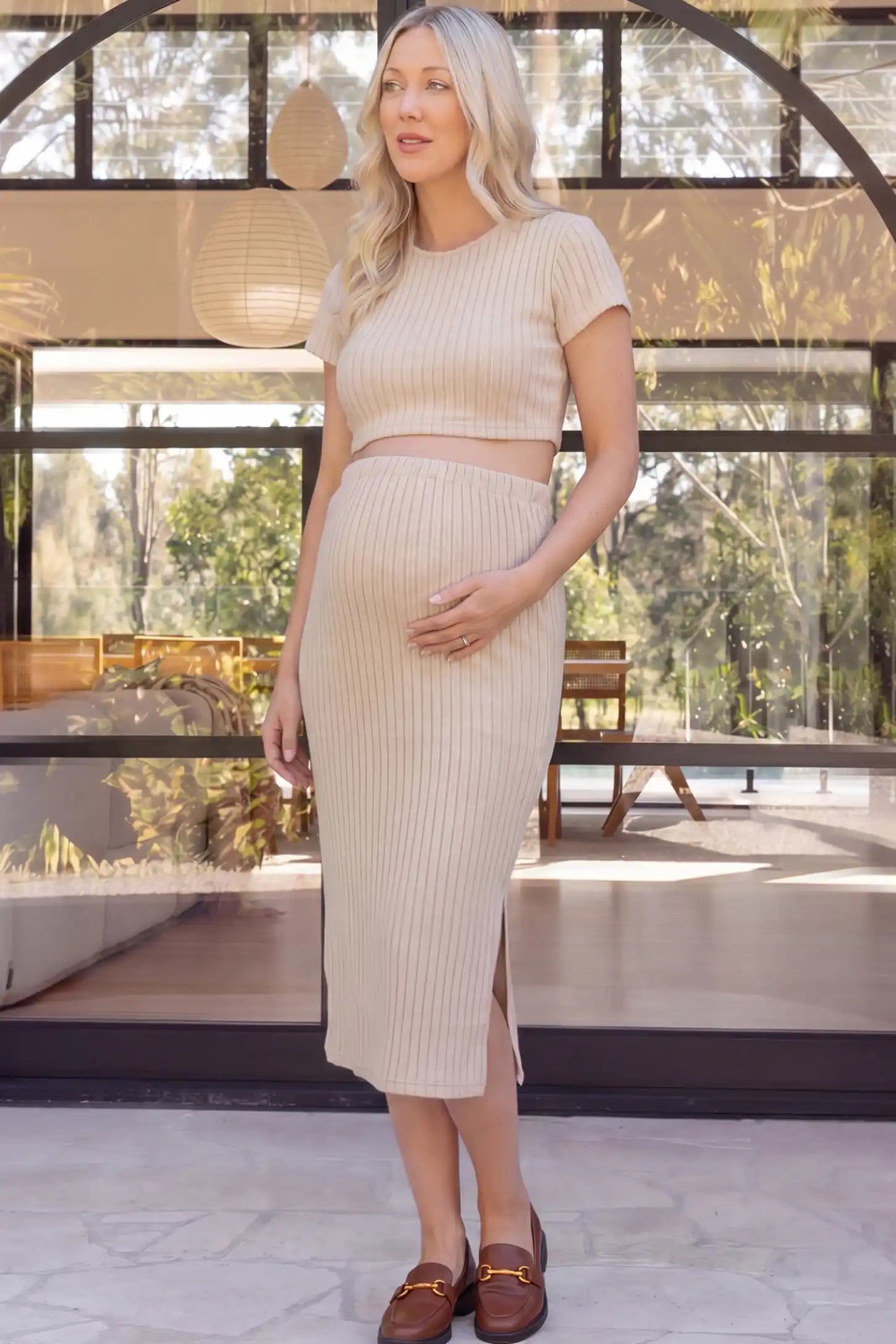 Ribbed Bodycon Crop Top & Skirt Maternity Set in beige featuring a fitted ribbed knit silhouette with side slit on a pregnant woman front view.