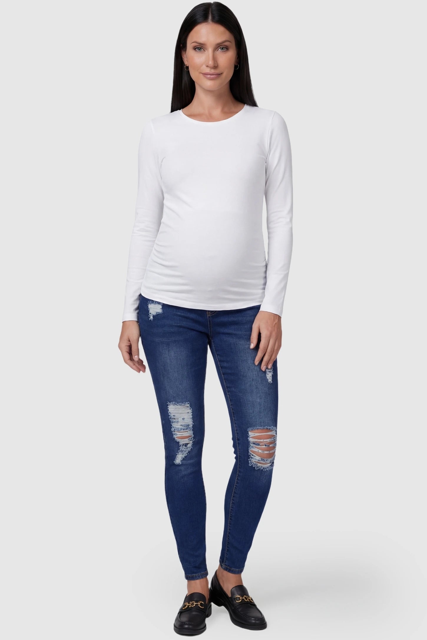 Distressed ripped high-waist skinny maternity jeans in dark blue with ripped design, full body on pregnant model