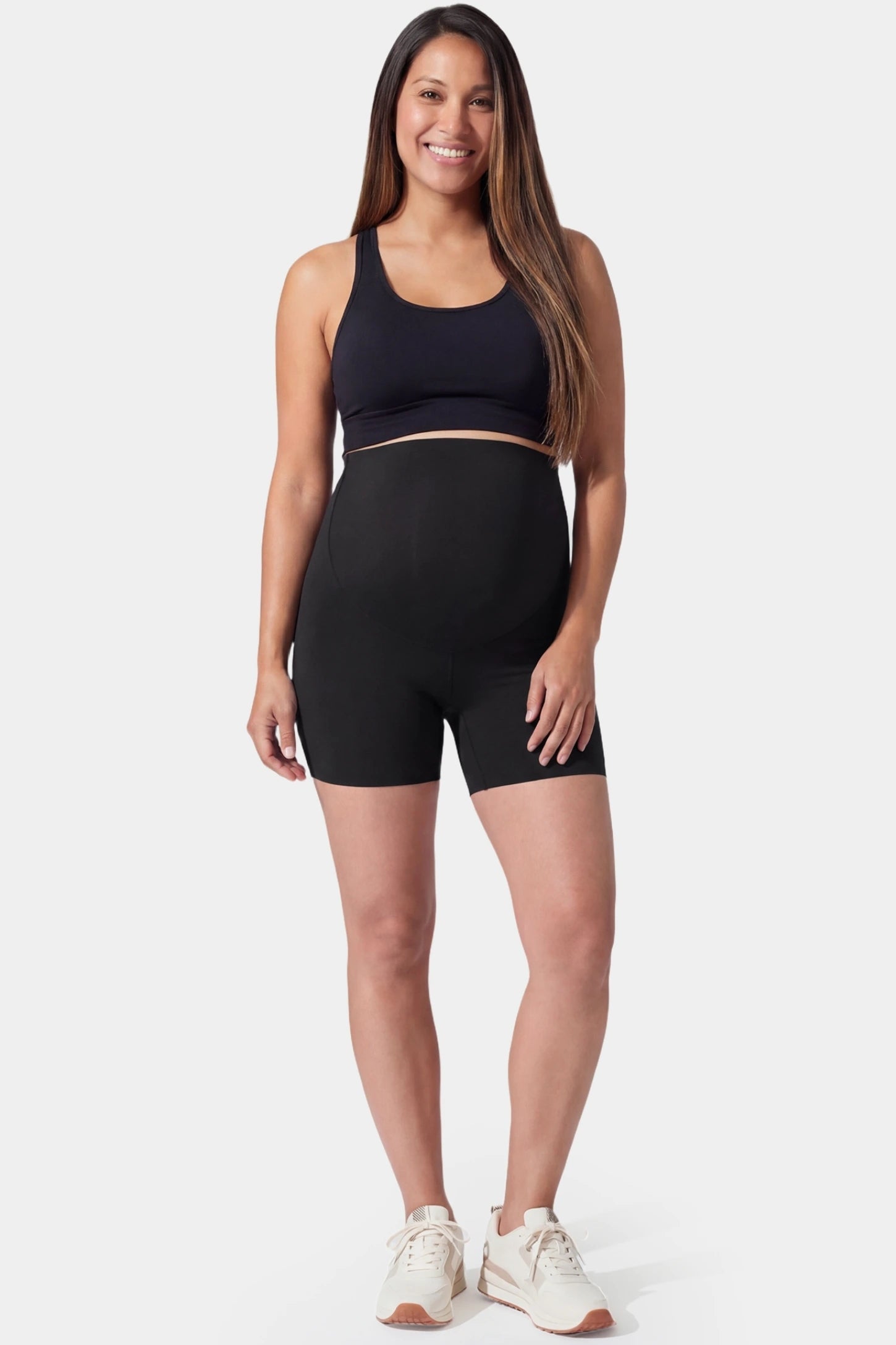 Seamless high-waist slim-fit maternity shorts in black with anti-exposure coverage, full body on pregnant model