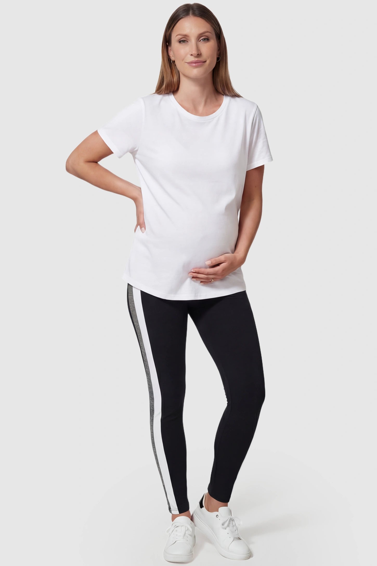 Stretch waist panel side-stripe maternity leggings in black with sleek sporty fit, full body front view on pregnant model