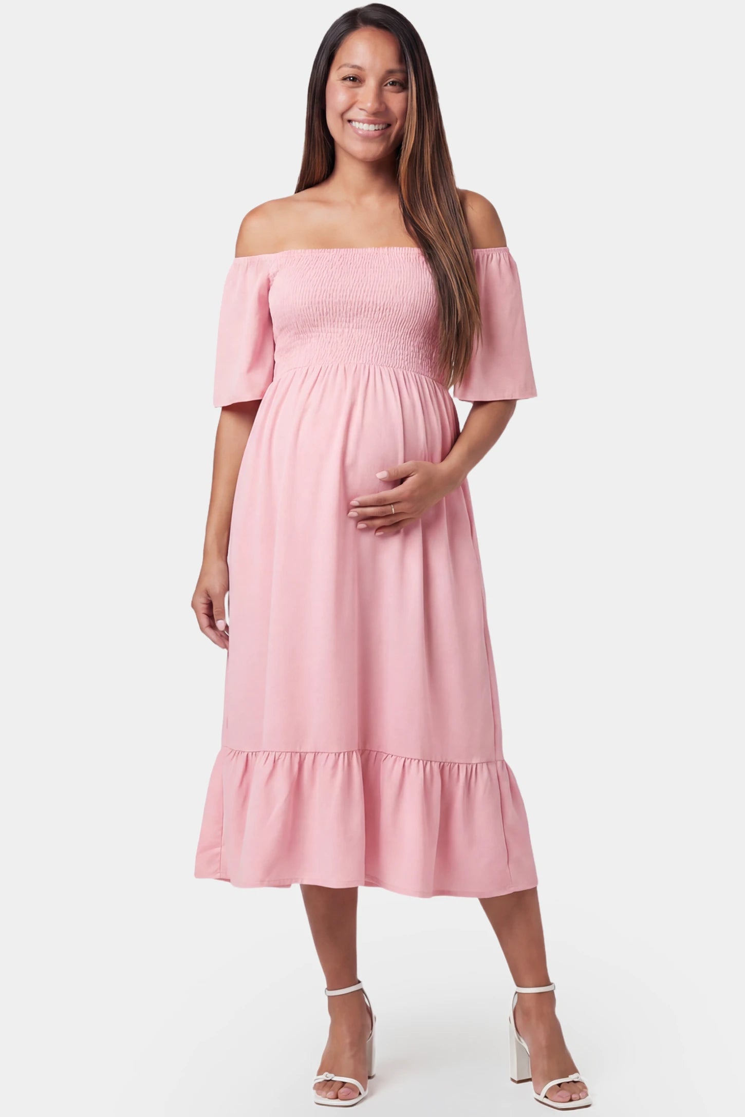 Off-shoulder smocked short sleeve A-line midi maternity dress in pink featuring smocked elastic waist in front view on a pregnant model