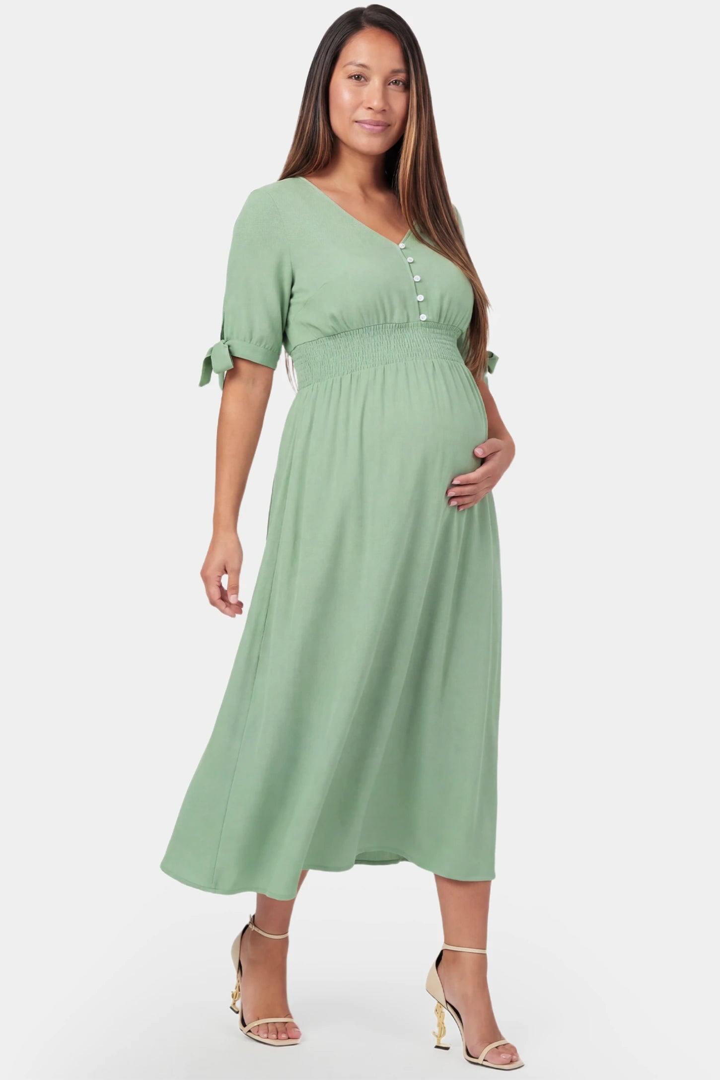 V-neck smocked waist A-line maxi maternity dress in mint green featuring button detail and V-neckline in front view on a pregnant model