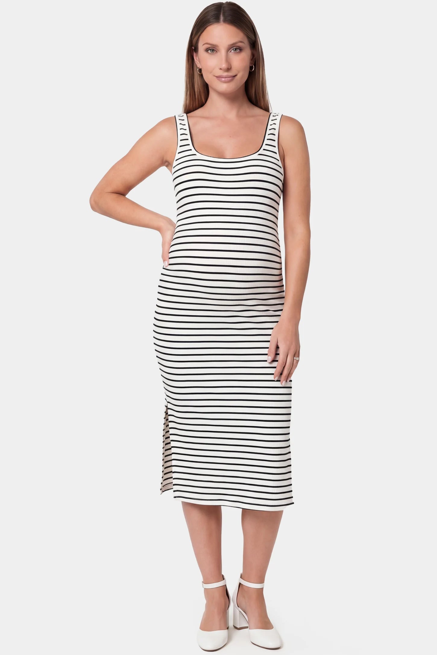 Striped spaghetti strap side slit midi maternity dress in white featuring classic black-and-white stripes in front view on a pregnant model