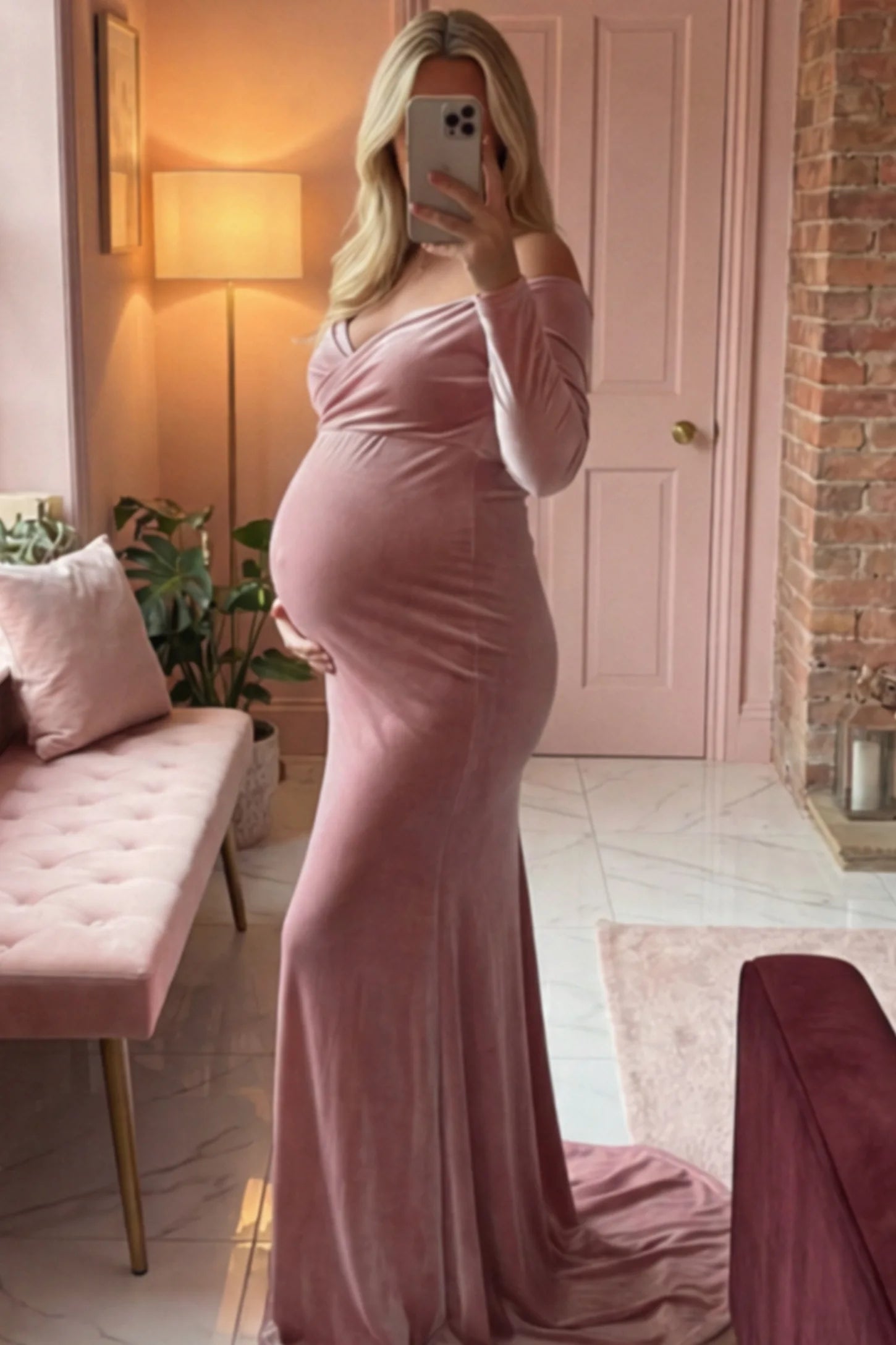 Velvet Long Fitted Sleeve Maternity Gown in pink featuring an off-shoulder sweetheart neckline, draped bust, empire waist, and mermaid skirt on pregnant model.
