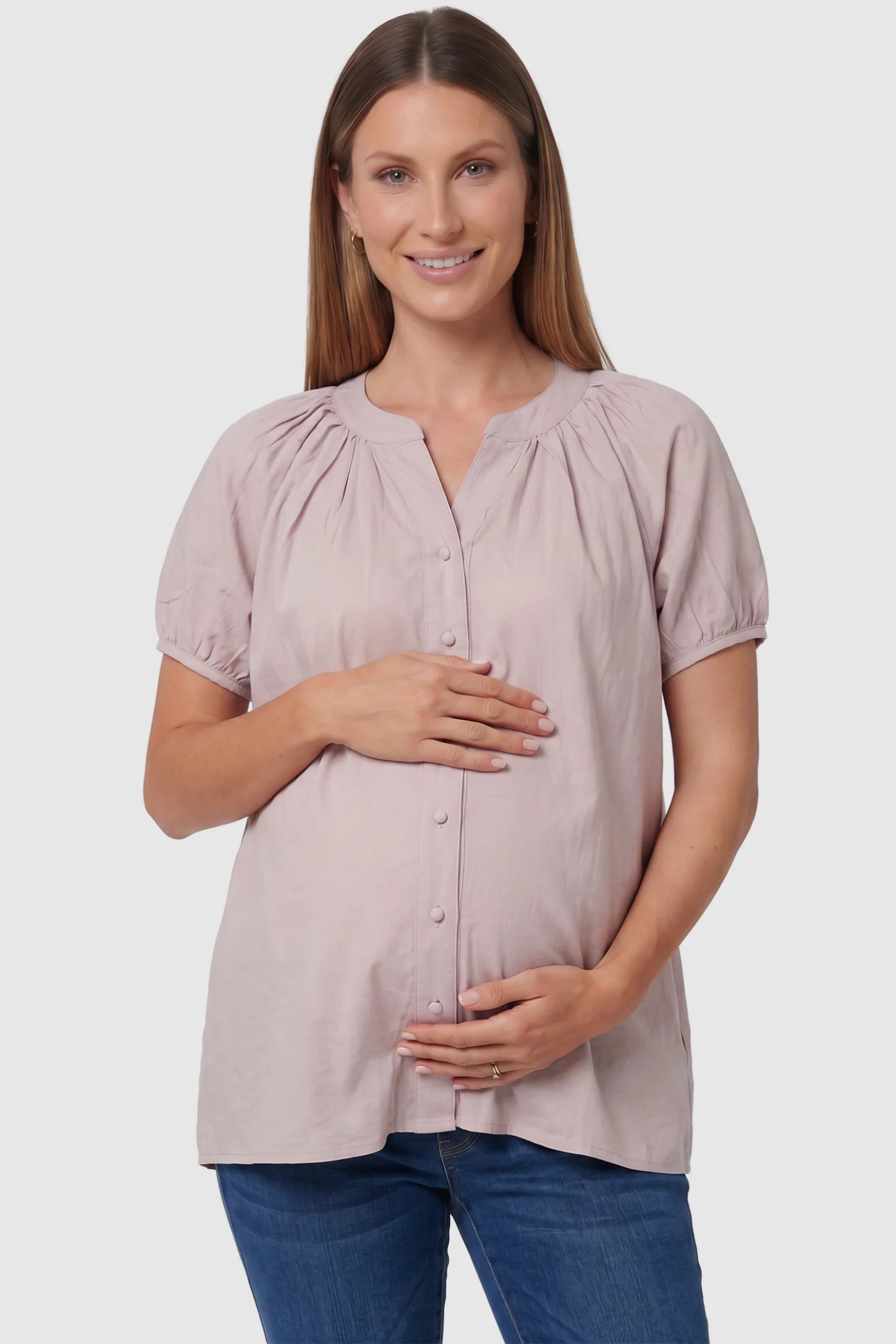 Button Front Short Sleeve Maternity Blouse in Pink featuring gathered fabric and a button-up neck on a pregnant model, front view.