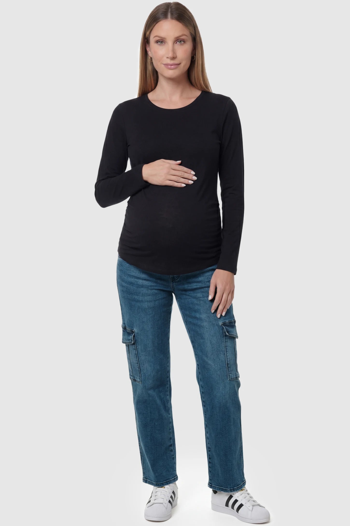 Full Panel Wide Leg Maternity Cargo Jeans in Denim Blue featuring functional side flap pockets on a pregnant model posing front.