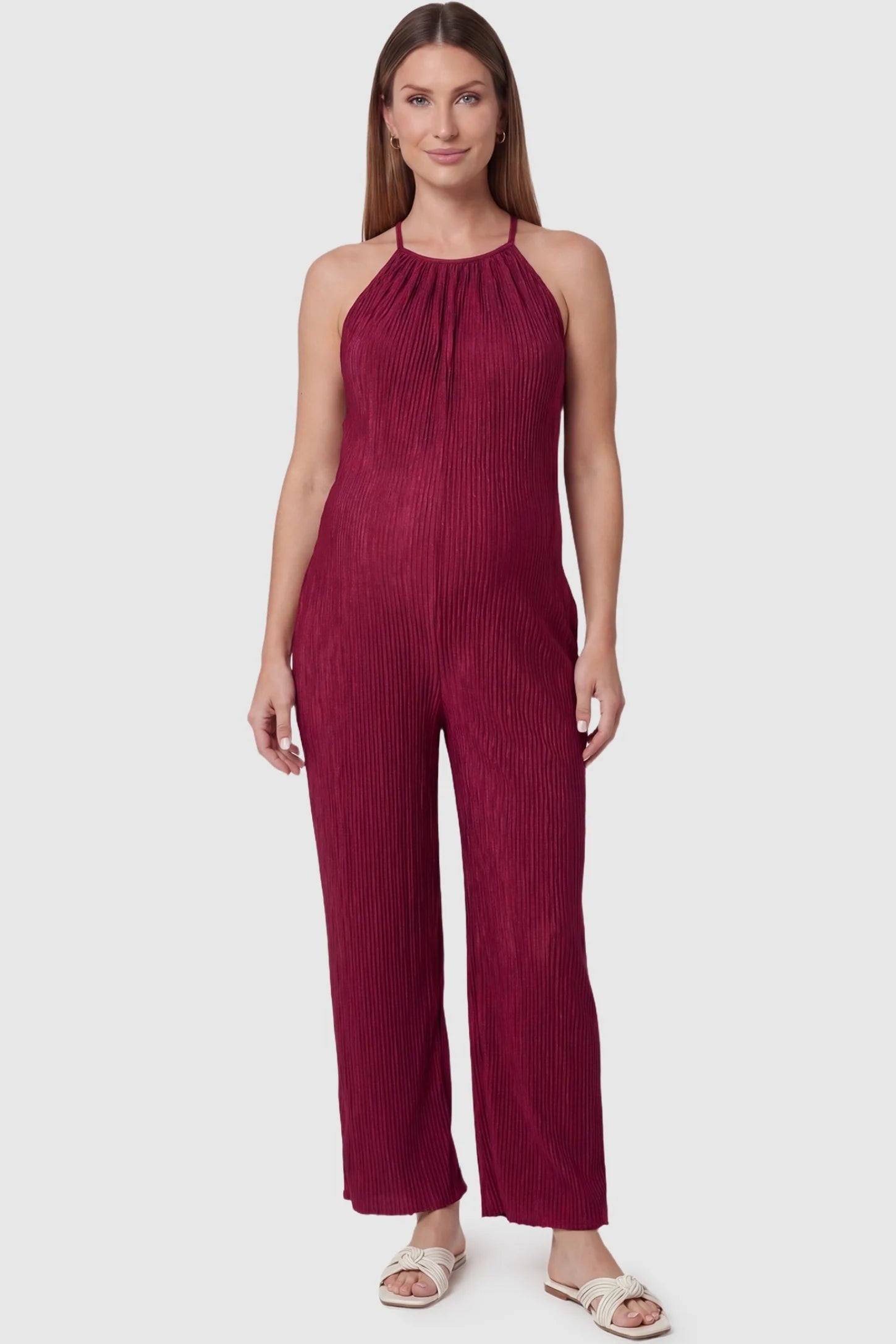 Halter Neck Wide Leg Pocketed Maternity Jumpsuit in Wine Red featuring a gathered halter neck and ribbed texture on a pregnant model, front view.