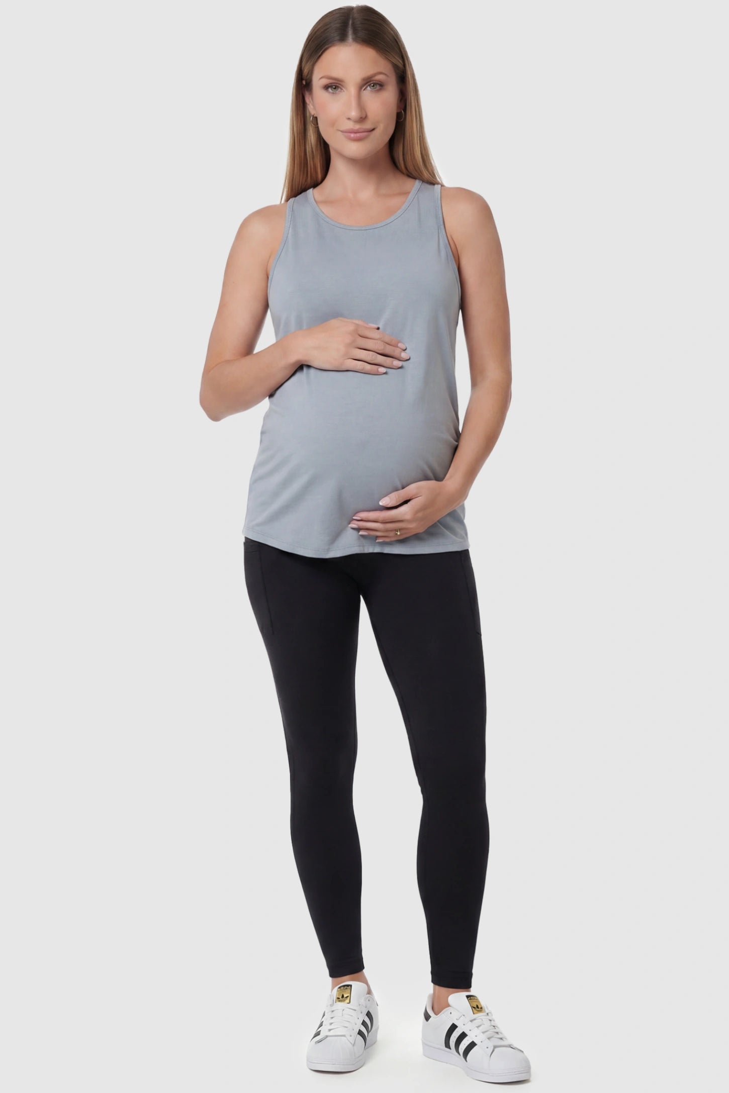 High-Waist Ankle-Length Pocketed Maternity Leggings in Black featuring a seamless waistband on a pregnant model, full body view.