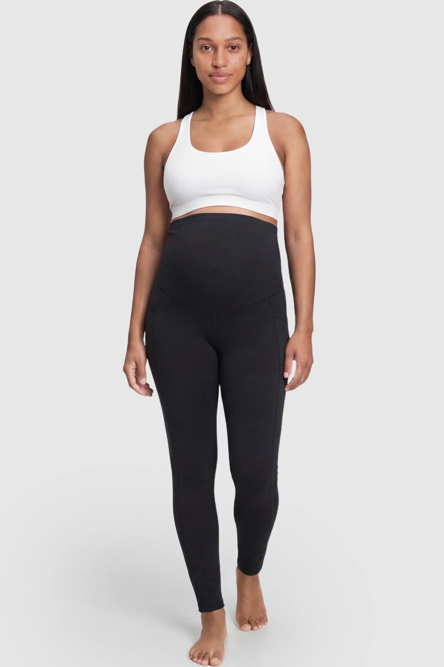 High Waist Full Panel Maternity Leggings in Black featuring side pockets on a pregnant model.