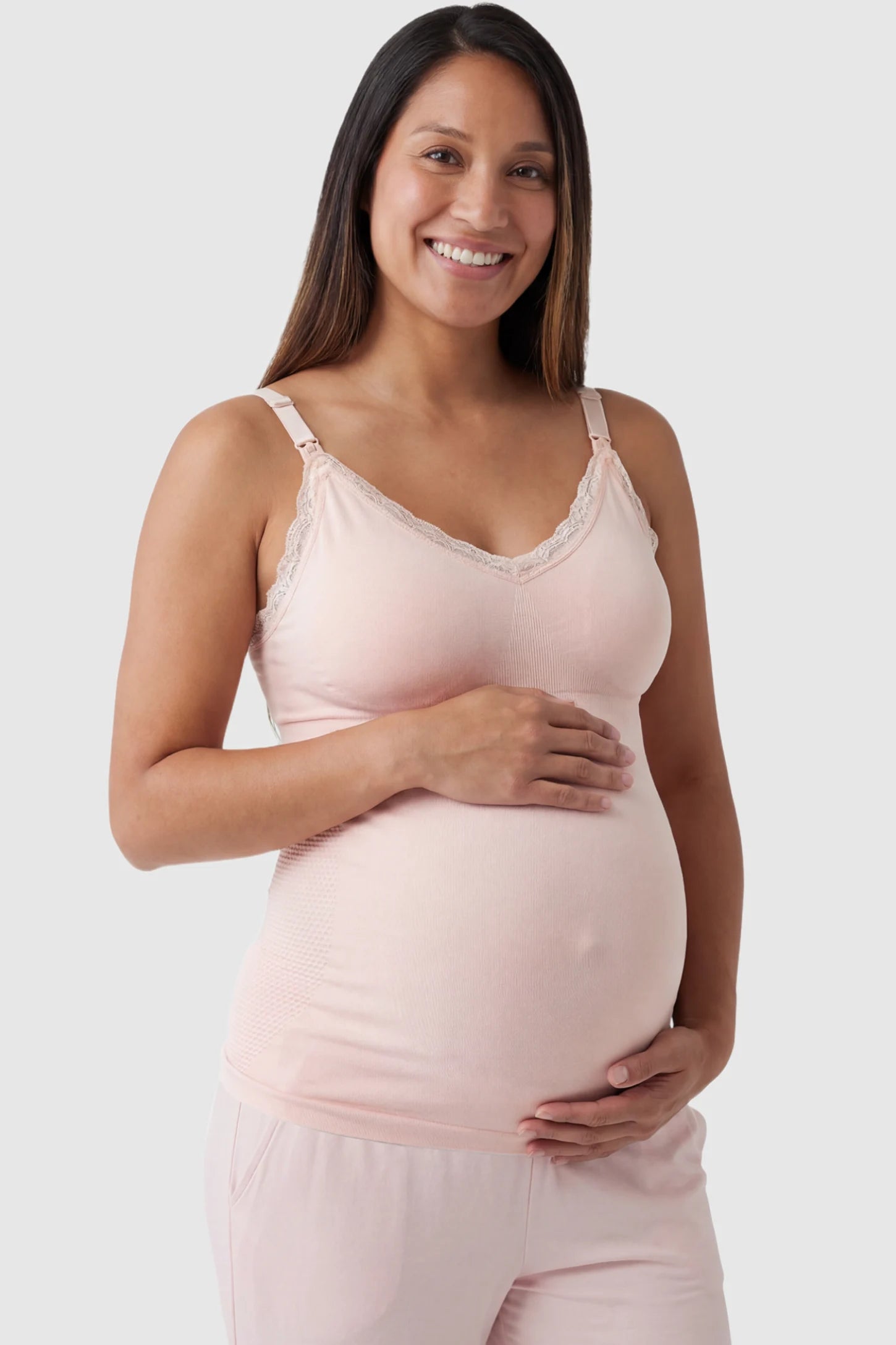 Lace Trim Wire Free Maternity Nursing Camisole in light pink offering one-handed nursing access on a pregnant model, front view.