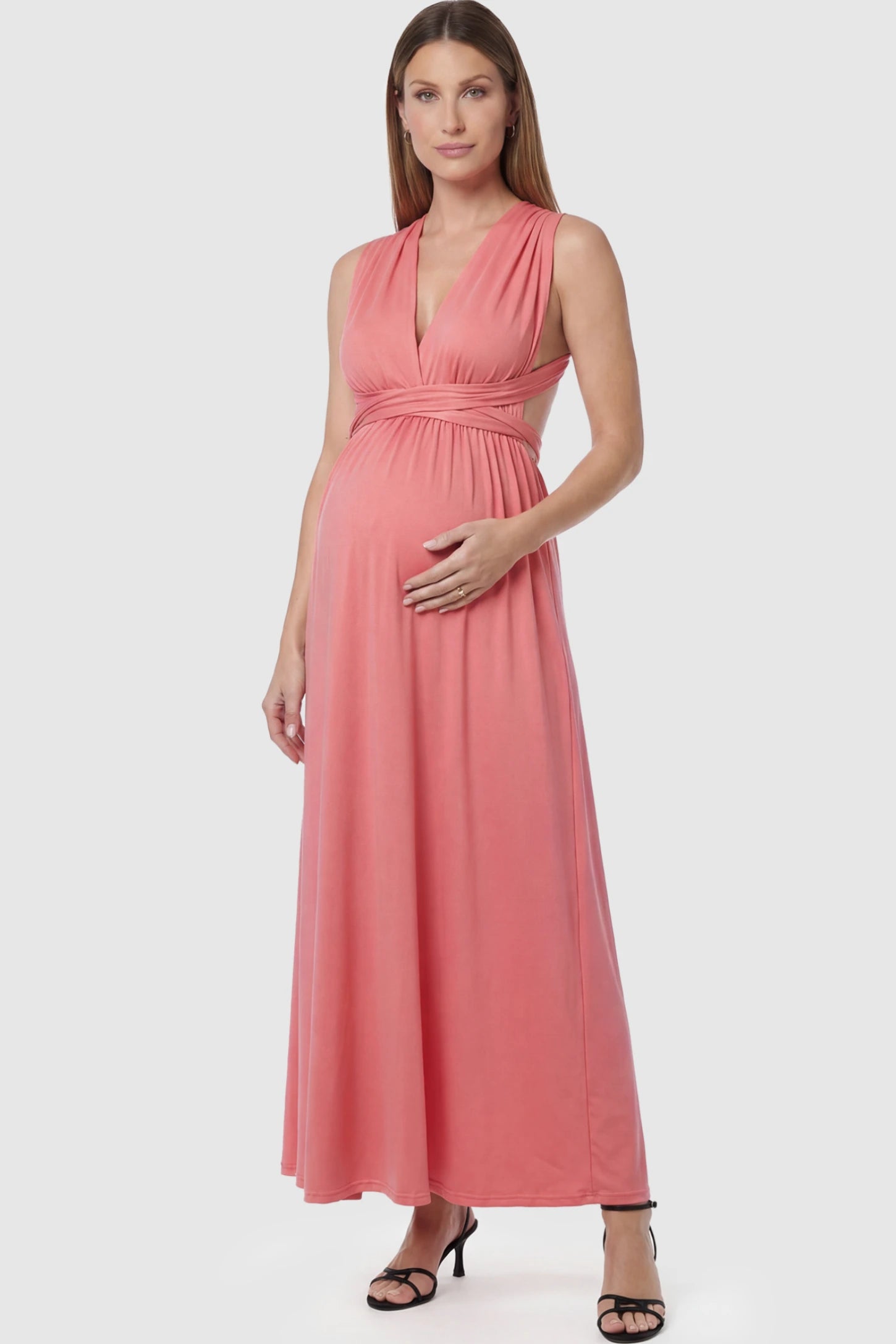 Plunging Halter Empire Waist Maternity Maxi Dress in Pink featuring high-stretch fabric on a pregnant model in a studio setting showing front.