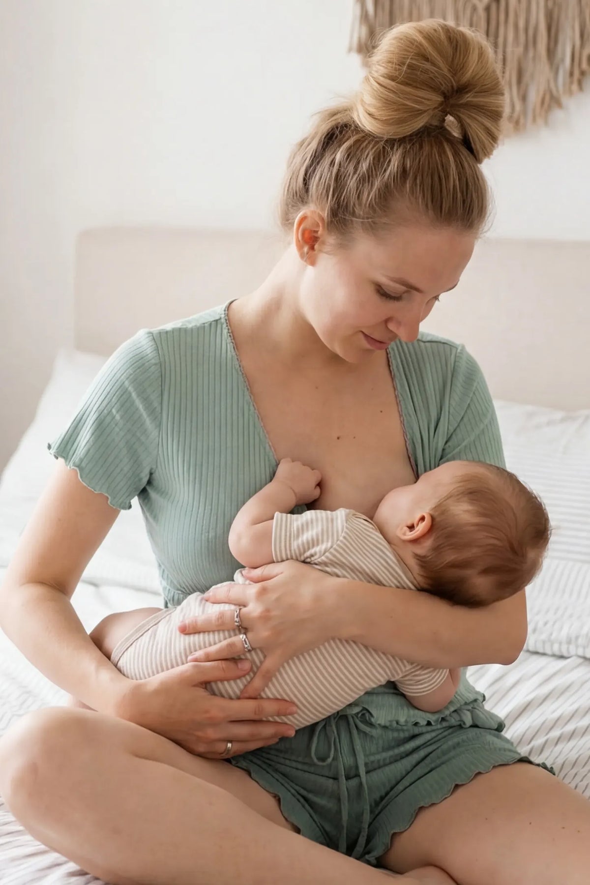 Ribbed Short Sleeve & Drawstring Shorts Maternity Pajama Set in Green featuring an intimate seated nursing moment on a non-pregnant model, editorial lifestyle view.