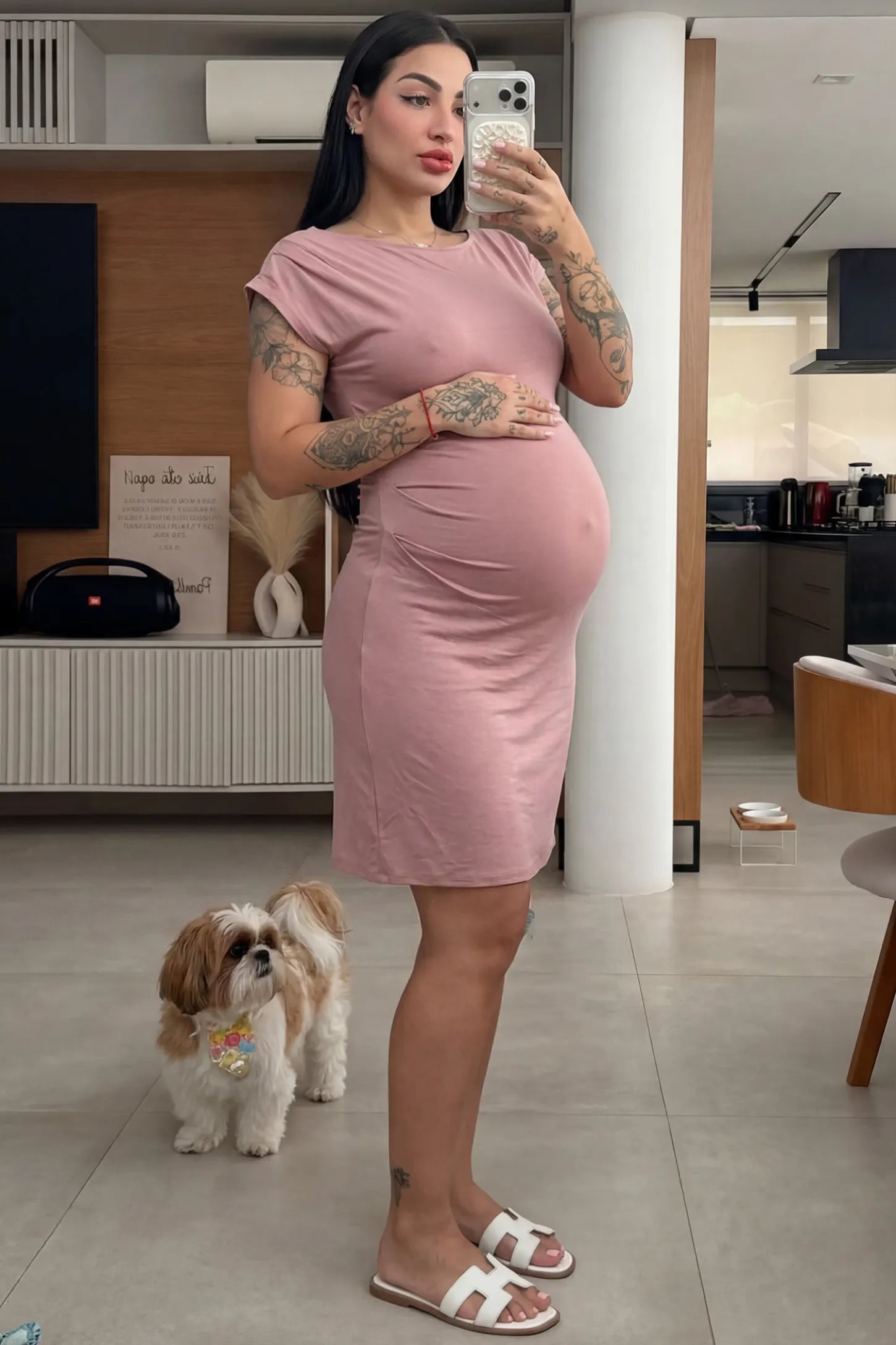 Side Ruched Boat Neck Maternity Mini Dress in Pink featuring side ruching at the waist on a pregnant model taking a mirror selfie indoors, front view.