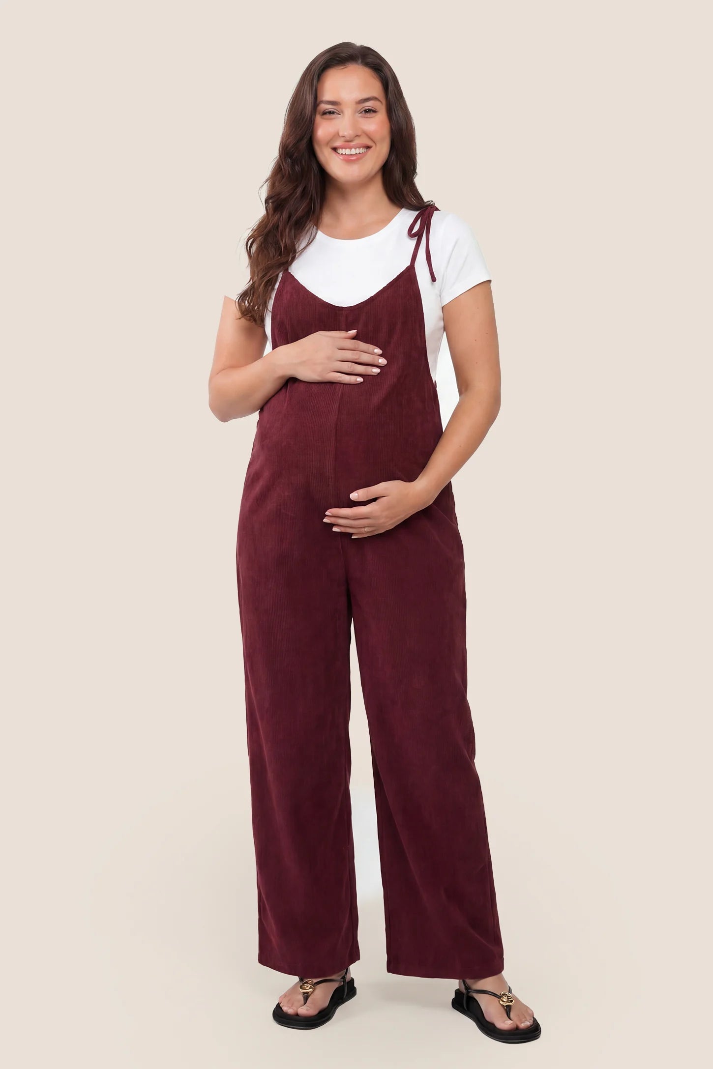 Solid Sleeveless Wide Leg Maternity Jumpsuit in Wine Red featuring a flowy silhouette on a pregnant model, front view.