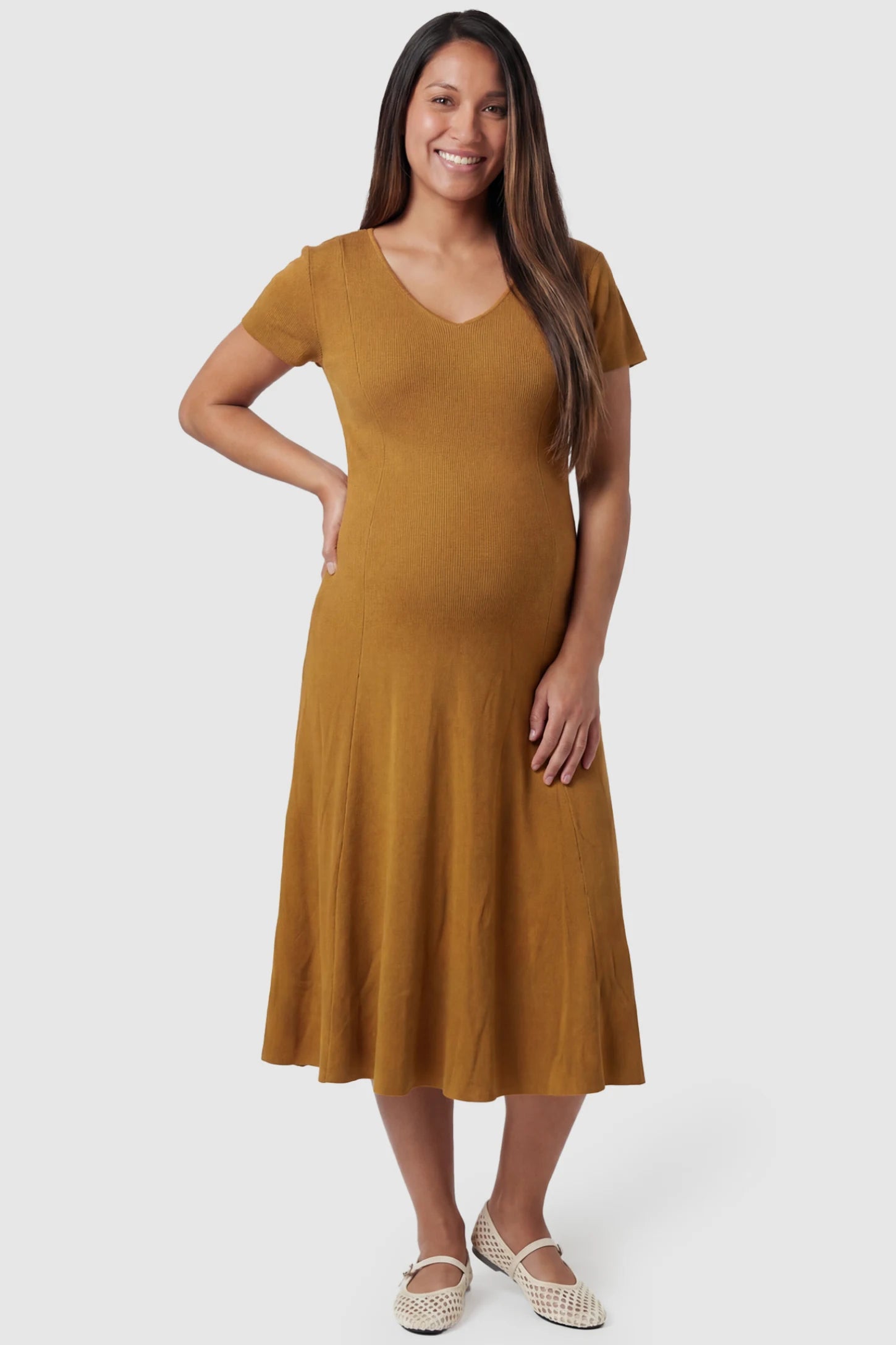 Soft Knit Stretch Short Sleeve Maternity Midi Dress in Camel featuring a flattering v-neck and high stretch knit on a pregnant model, front view.