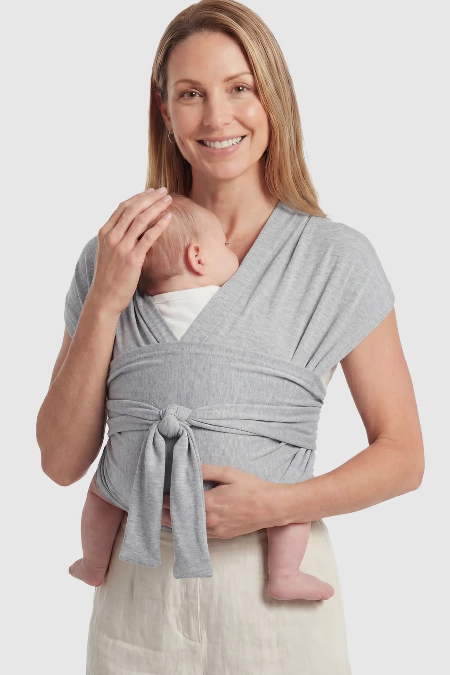 Soft Stretch Skin Friendly Baby Wrap Carrier in Light Gray featuring a secure front-tie knot on a mother holding her newborn showing front.