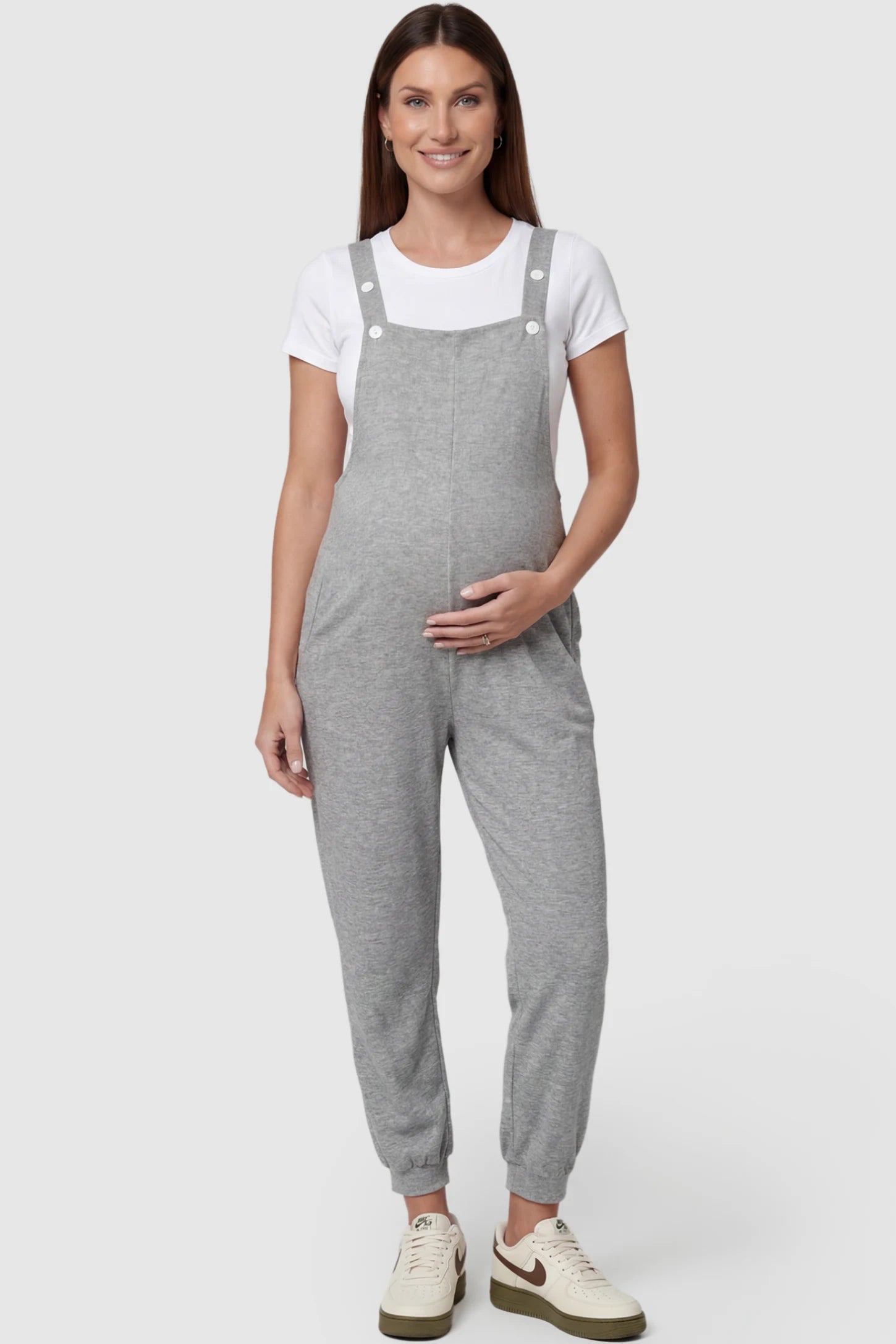 Square Neck Pocketed Maternity Jogger Jumpsuit in gray featuring button straps on a pregnant model, front view.