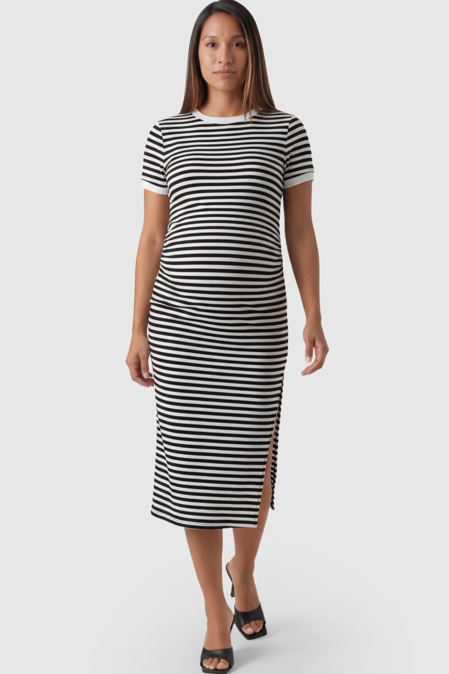 Striped Side-Slit Bodycon Maternity Midi Dress in Black and White featuring a side slit on a pregnant model posing front.