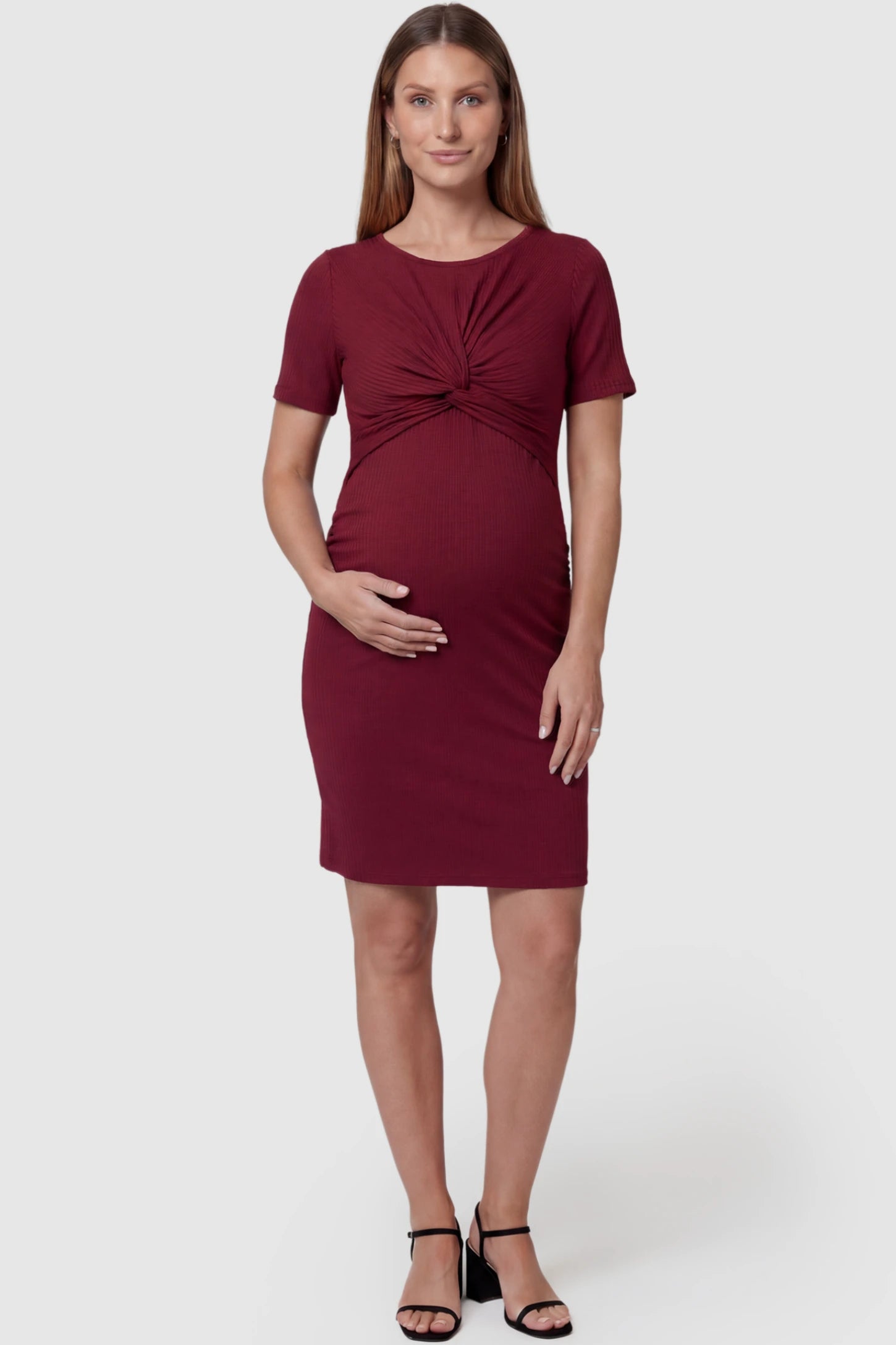 Twist Front Round Neck Maternity Short Dress in wine red featuring side ruched panels on a pregnant model, front view.