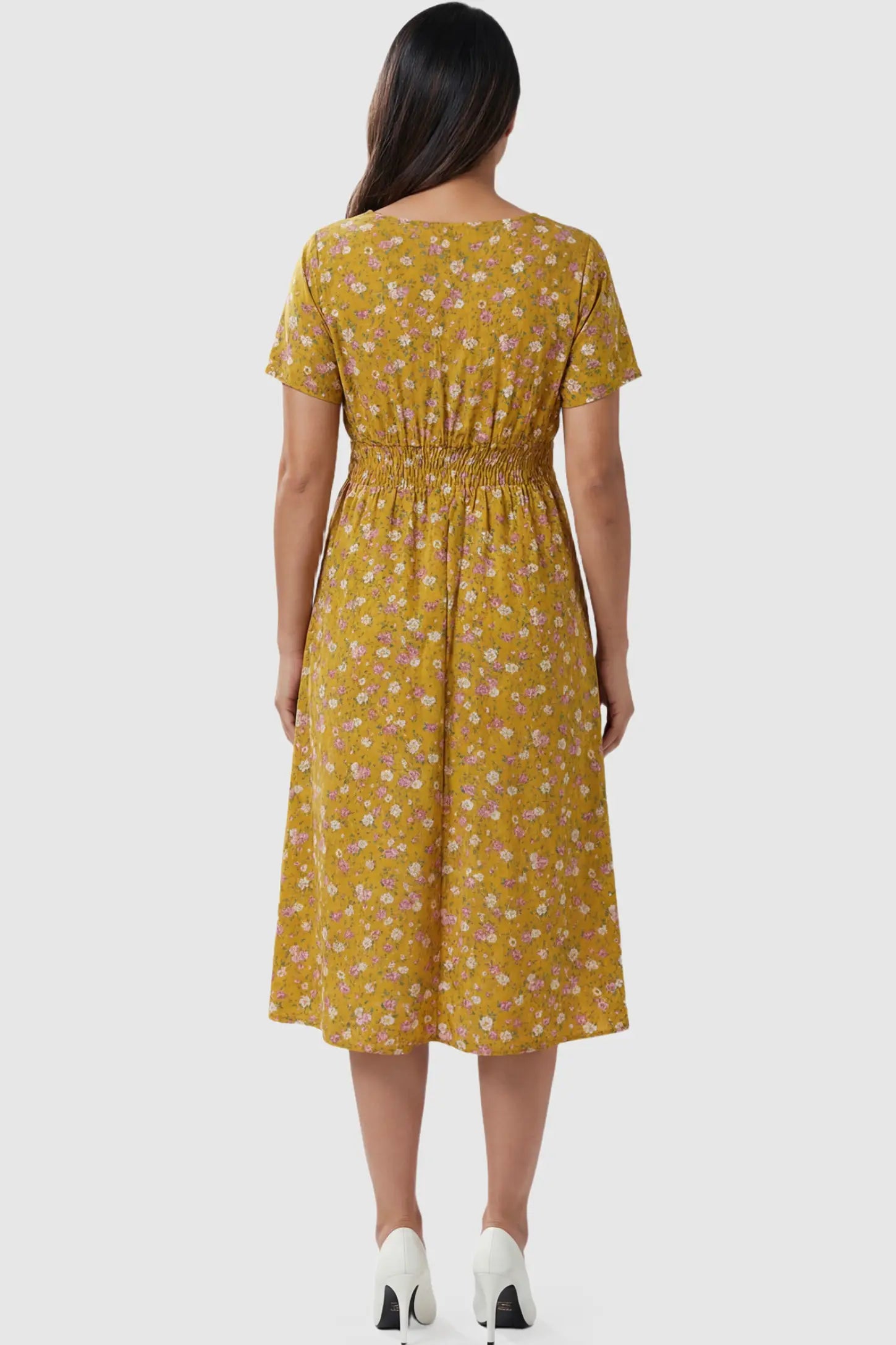 Smocked Waist Crossover Maternity Midi Dress Smocked Waist Crossover Maternity Midi Dress in yellow floral print featuring smocked bodice and A-line midi skirt on pregnant model.