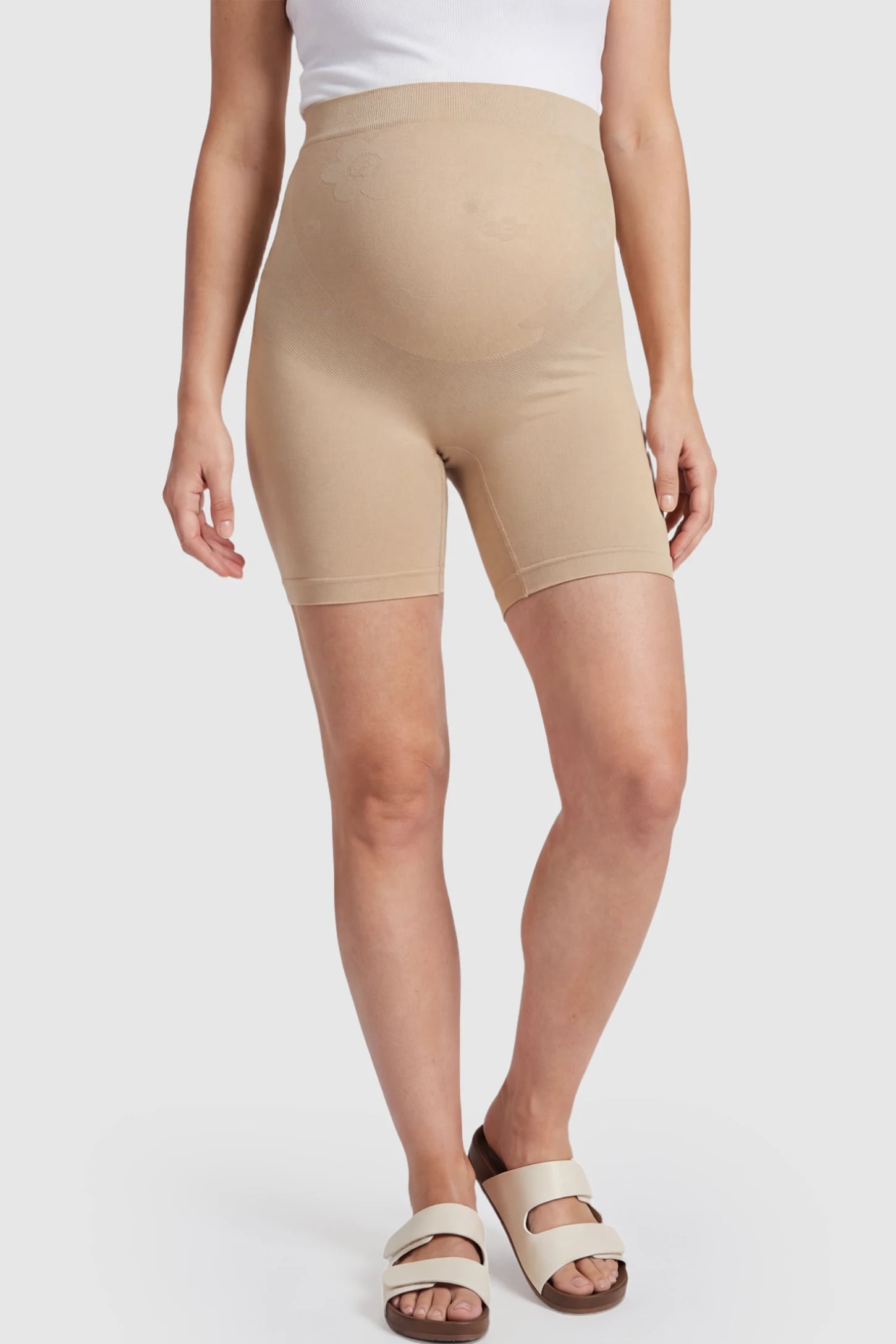 Seamless High-Waisted Mid Thigh Maternity Shapewear Shorts in Nude featuring a smooth belly support panel on a pregnant model.