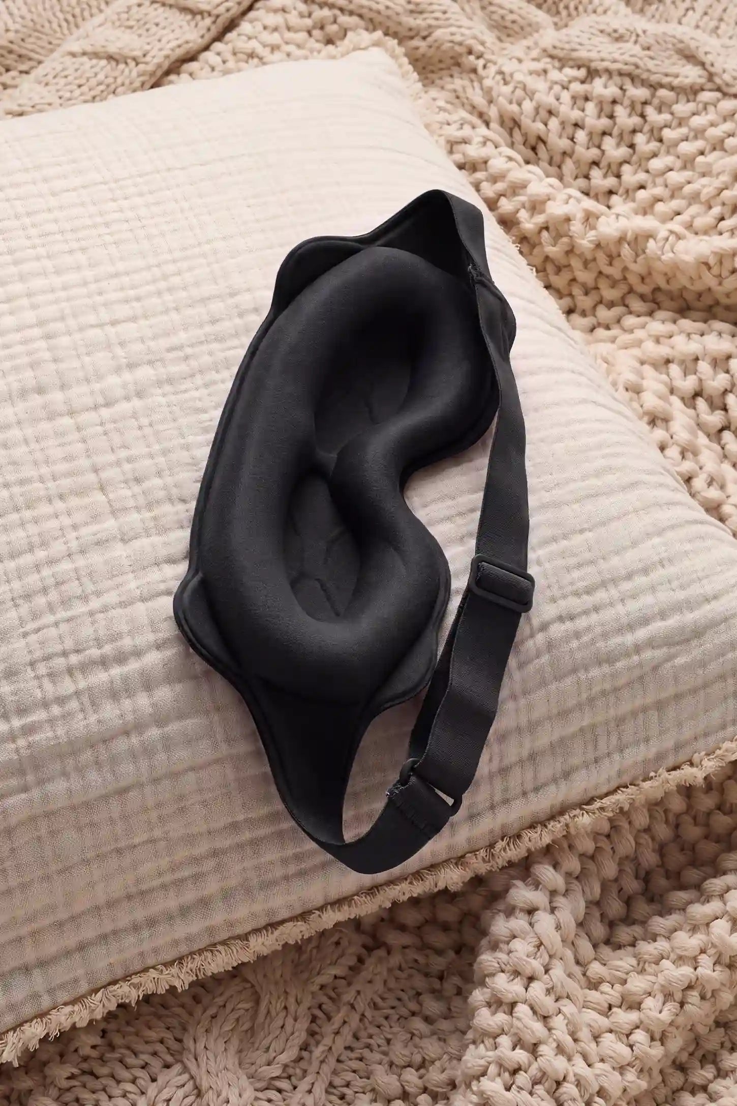 3D Contoured Blackout Sleep Mask 3D Contoured Blackout Sleep Mask in Black featuring inner eye cavity contouring, soft cushioned nose bridge, and adjustable elastic strap displayed on a wooden nightstand, lifestyle setting.